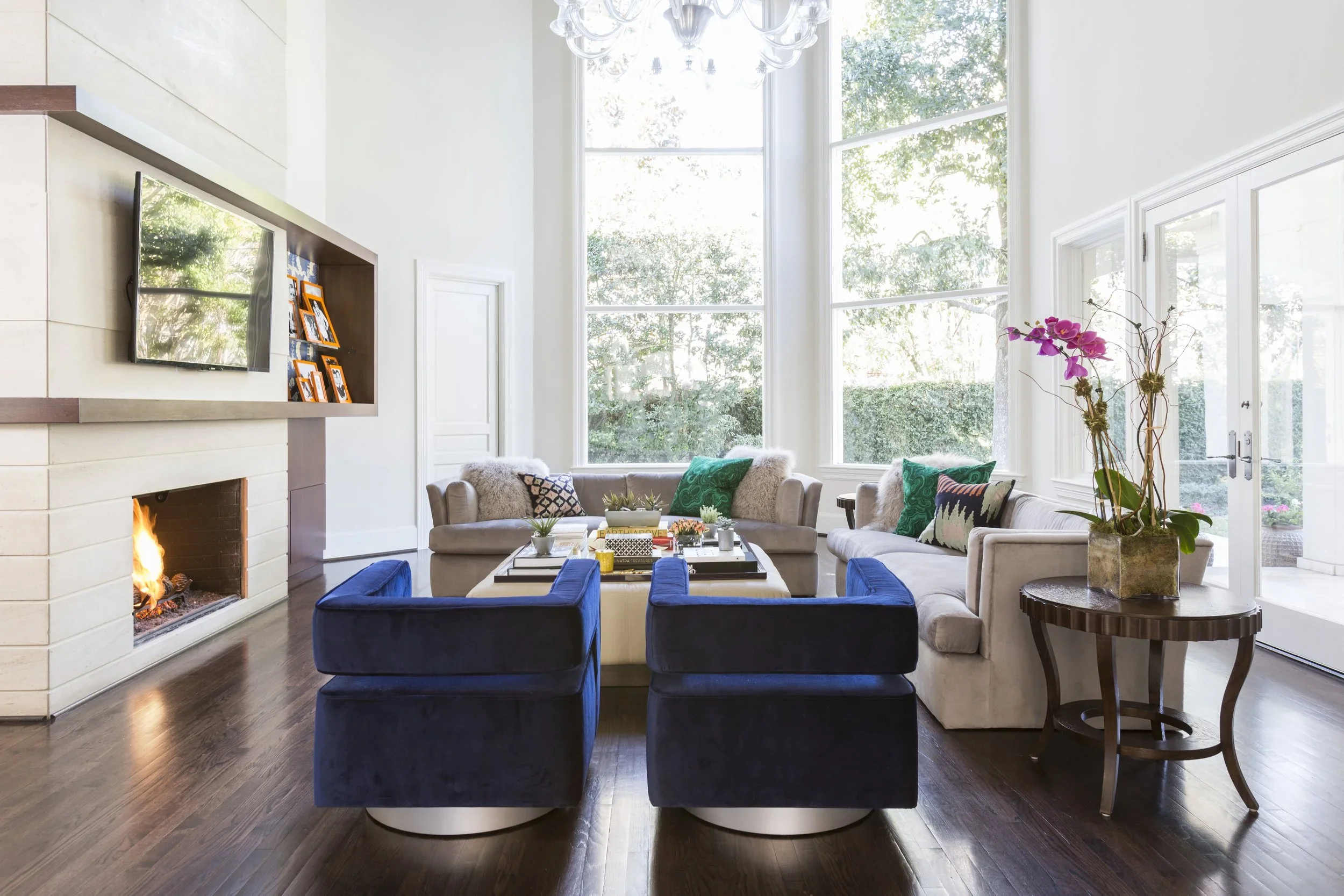 High-ceiling lounge interior with large windows, fireplace seating and polished modern furnishings for a luxury commercial setting