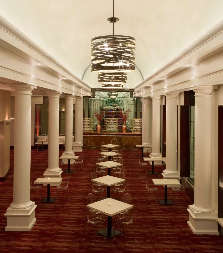Commercial interior design Houston lobby in Uptown/Galleria with classical columns, statement pendants and red flooring.
