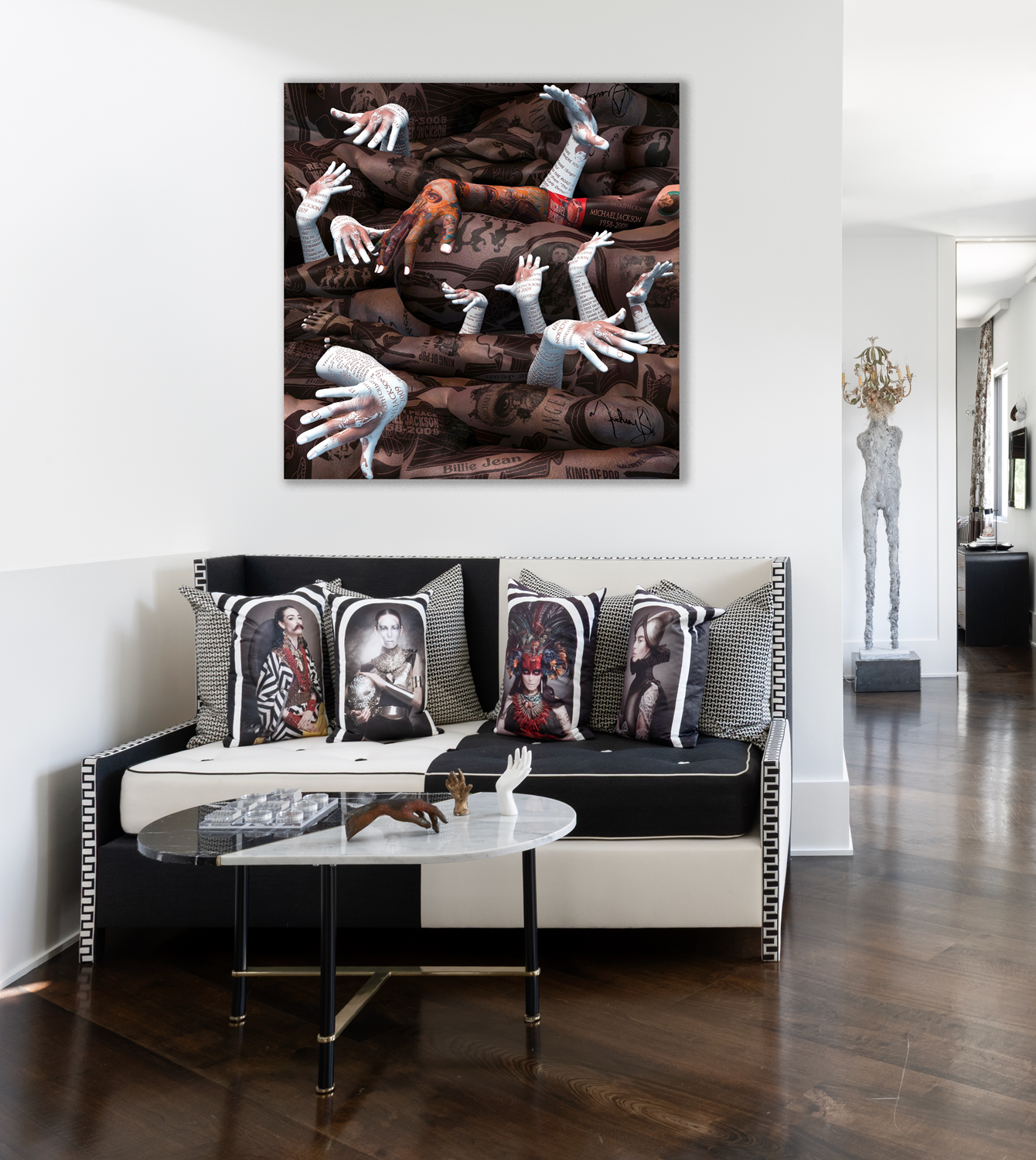 Modern luxury home in Houston sitting area with a monochrome sofa, portrait pillows, marble table and statement art.