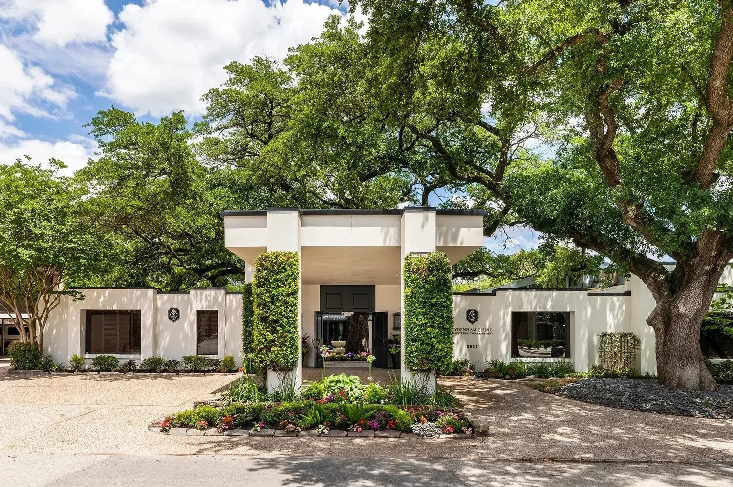 Commercial interior design Houston healthcare project showing the Sydenham Clinic exterior and tree-lined entrance.