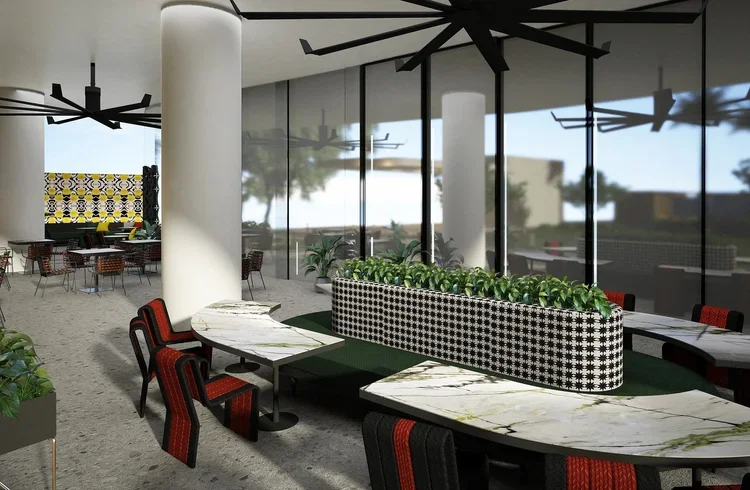 Rooftop dining area at Thompson Hotel Houston with marble tables, patterned banquette seating, greenery and sculptural black ceiling fans.