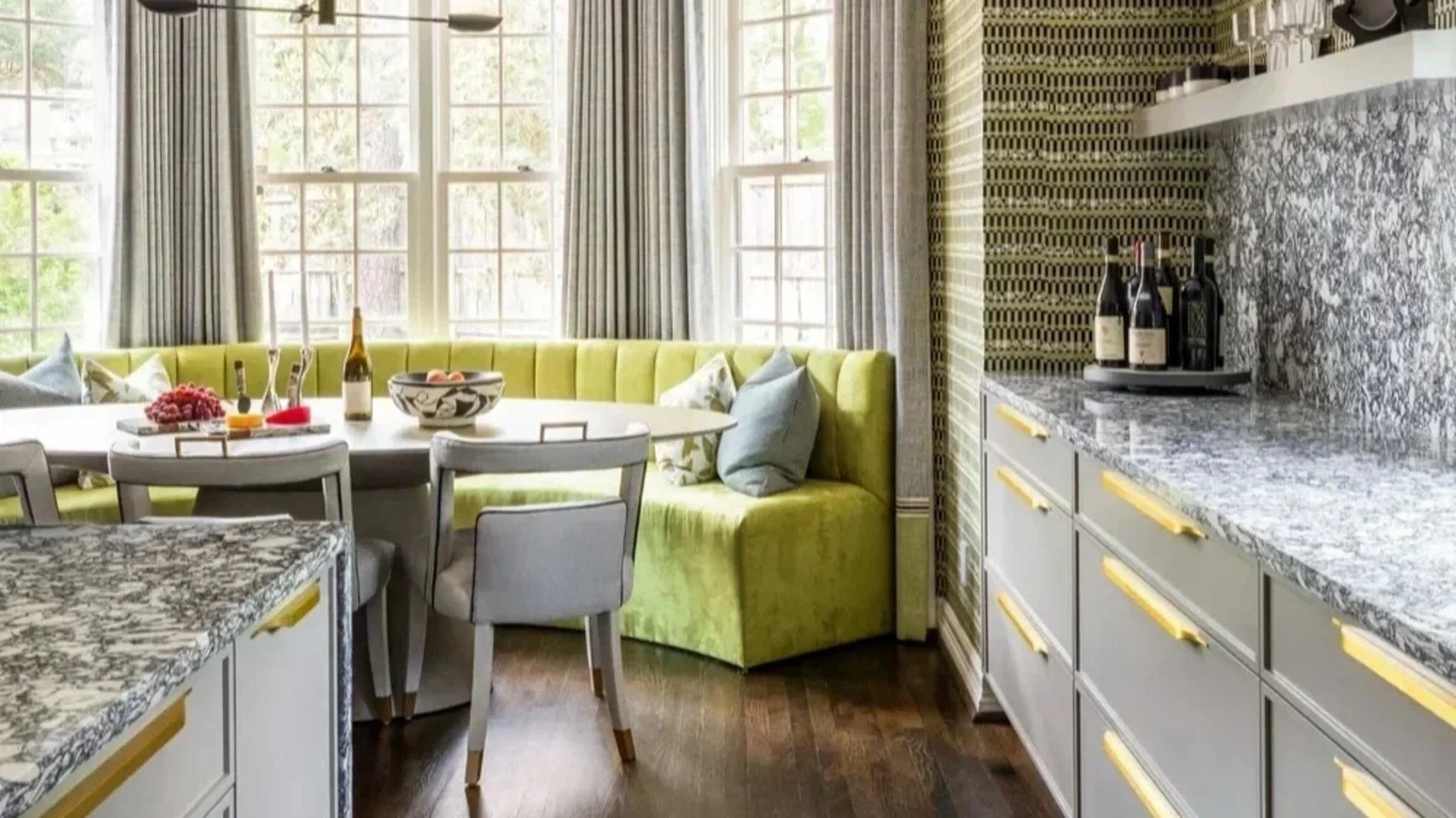 Bunker Hill residence kitchen breakfast nook with a lime-green banquette, patterned stone surfaces and brass detailing.