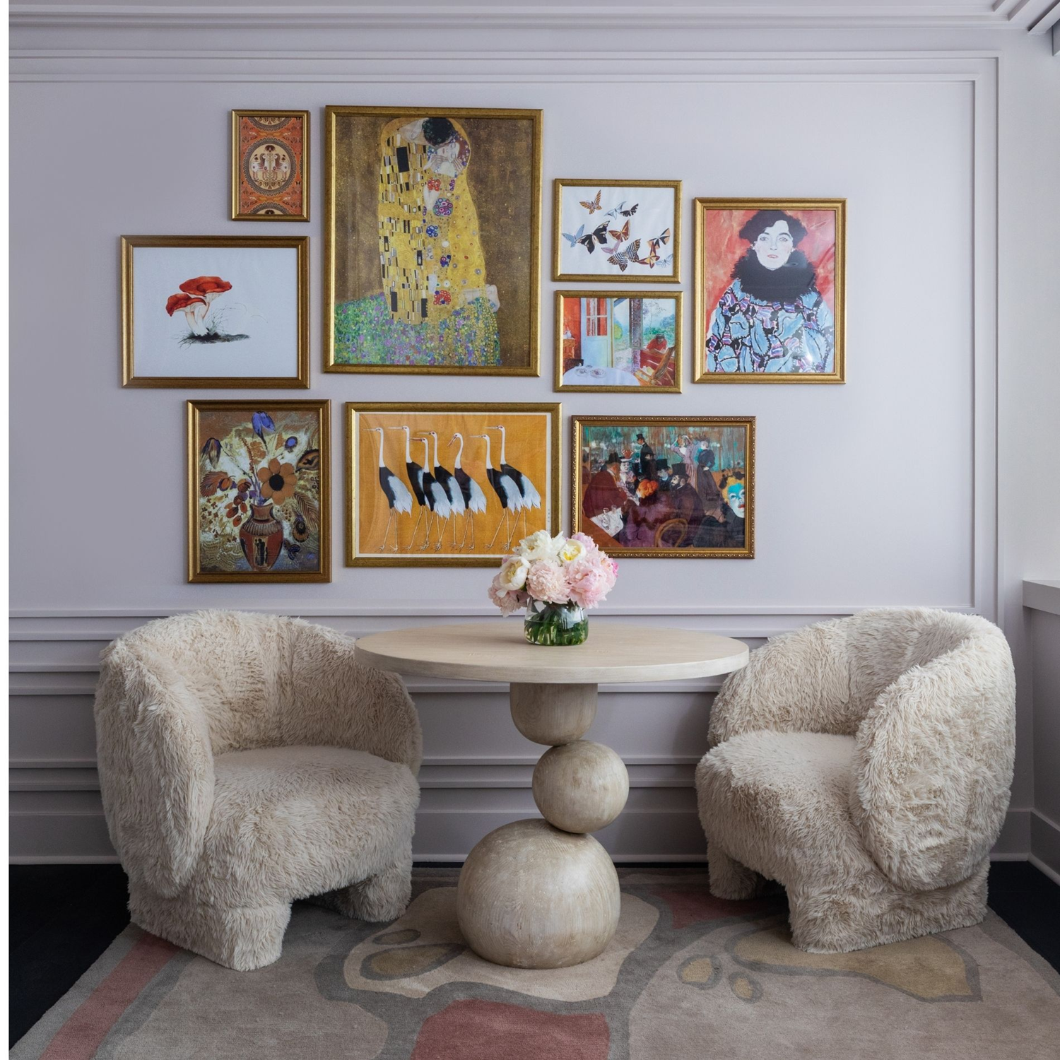 Wellness clinic Houston seating area with two plush cream chairs, a sculptural table and a colourful gallery wall.