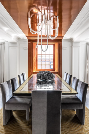 New York dining room with a copper-toned ceiling and statement lighting, illustrating architect and developer collaboration.