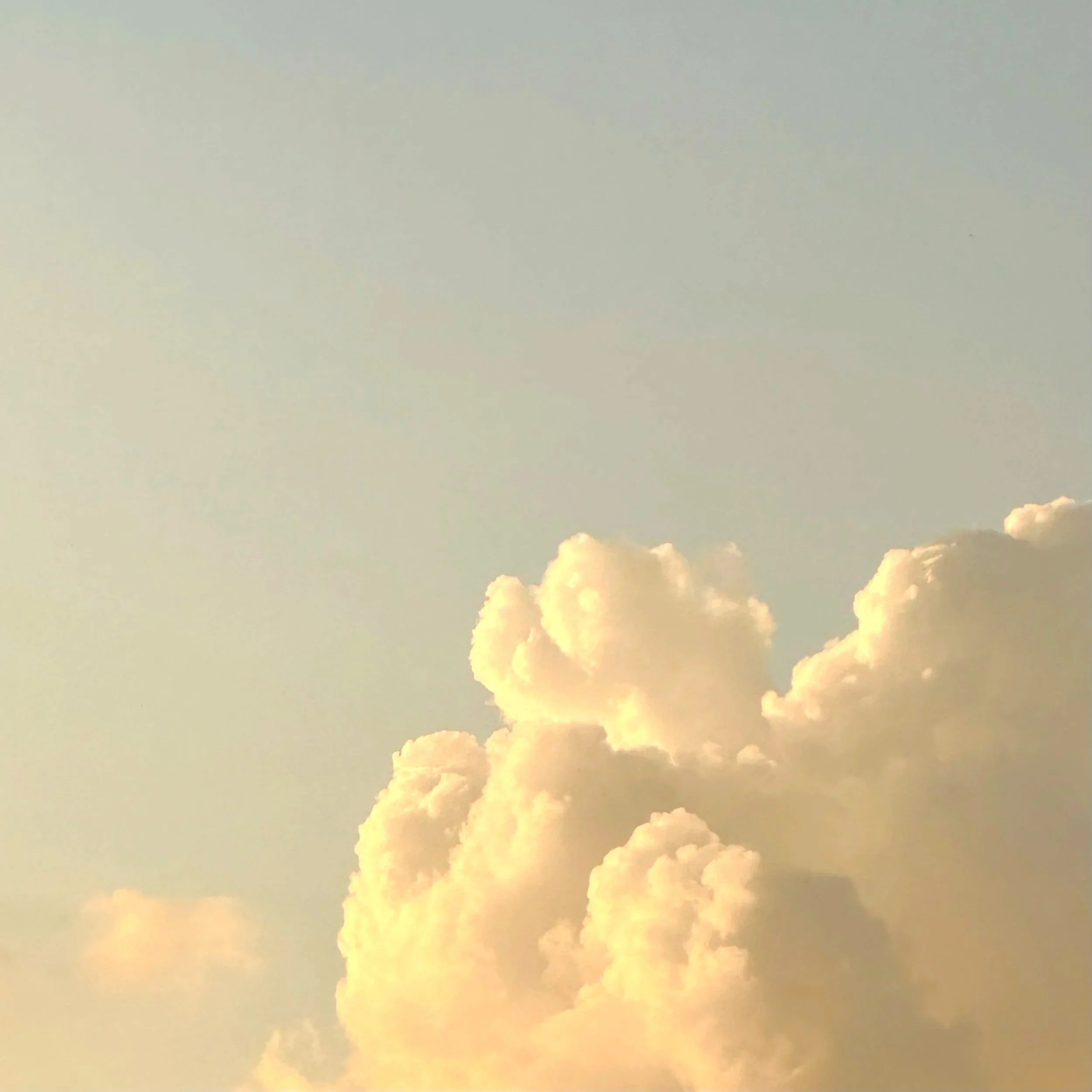 Sky with soft, fluffy clouds during sunset or sunrise.