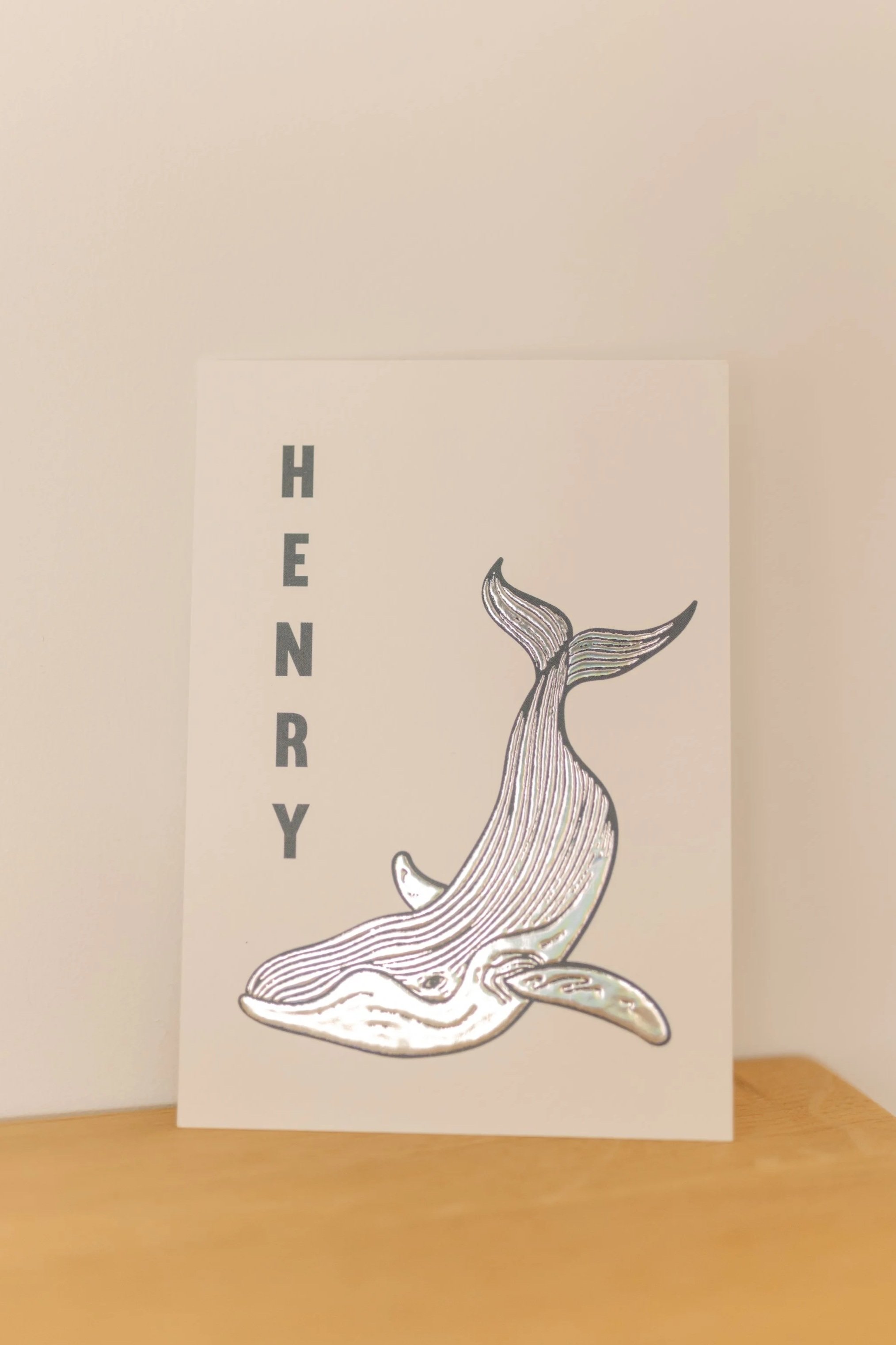 Een ansichtkaart met een tekening van een walvis en de tekst 'HENRY' links ernaast.