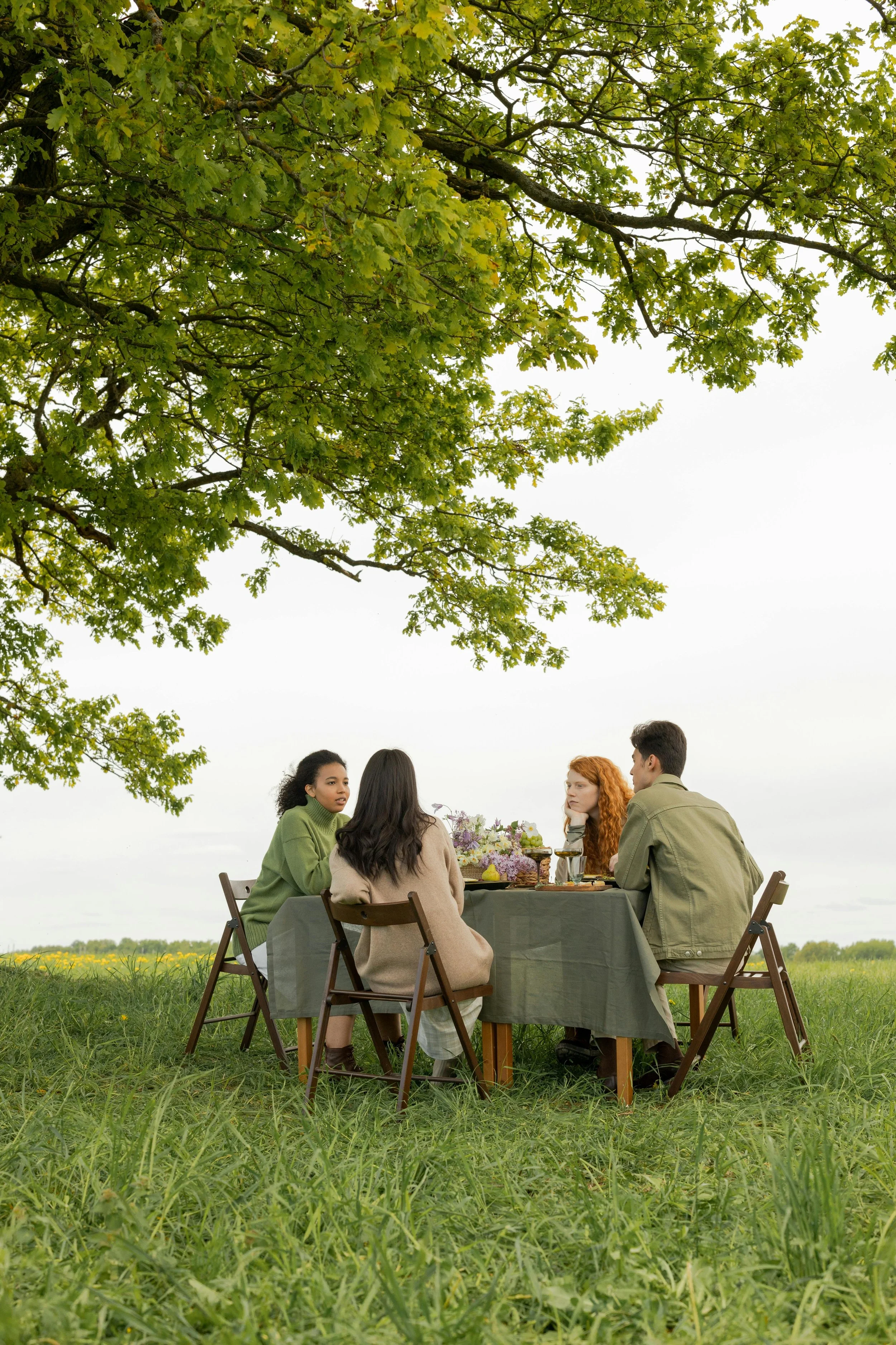A small group of internationals sitting together outdoors, symbolising community and connection in Denmark.