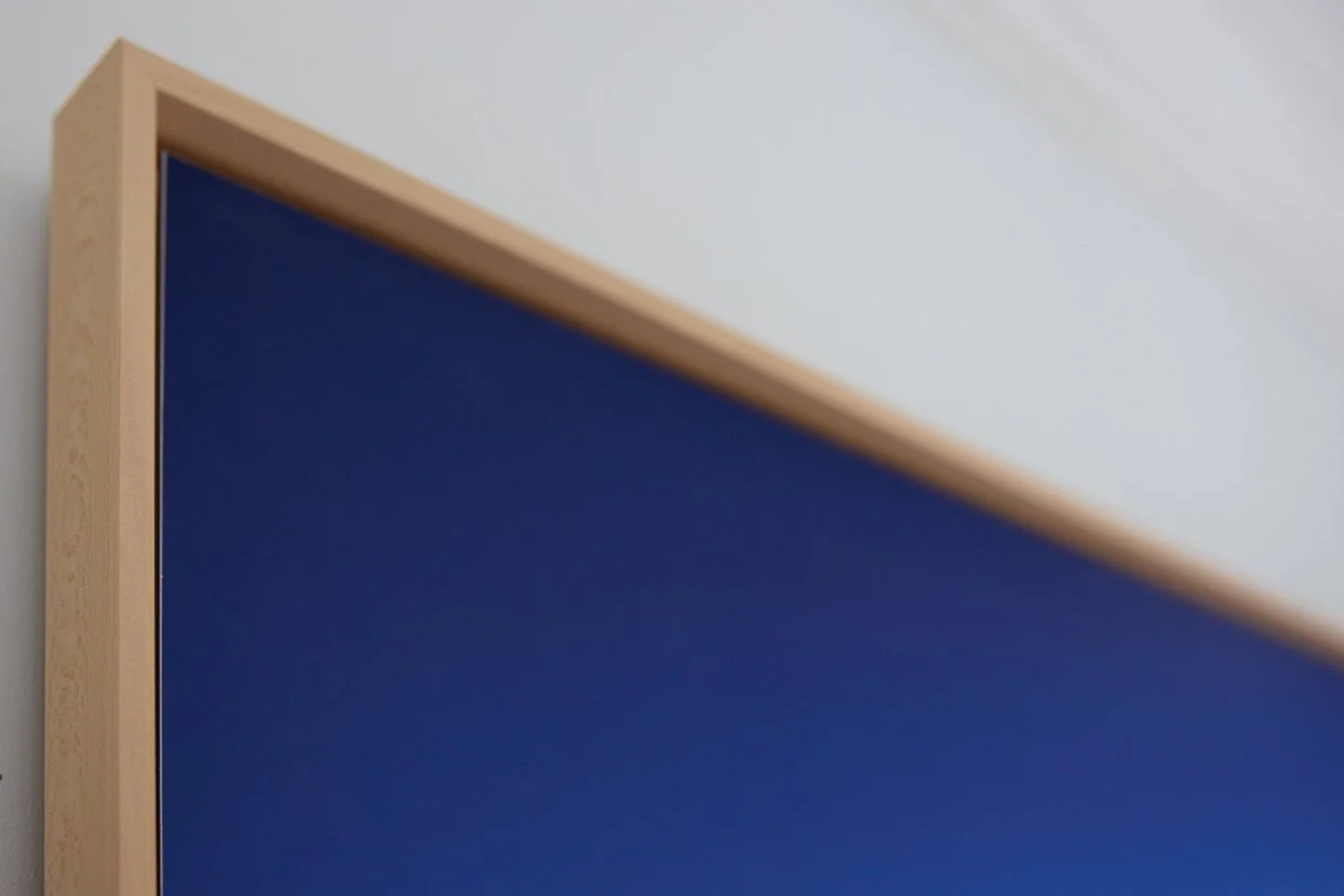 Un coin d'un tableau ou un panneau avec une structure en bois et une surface bleue