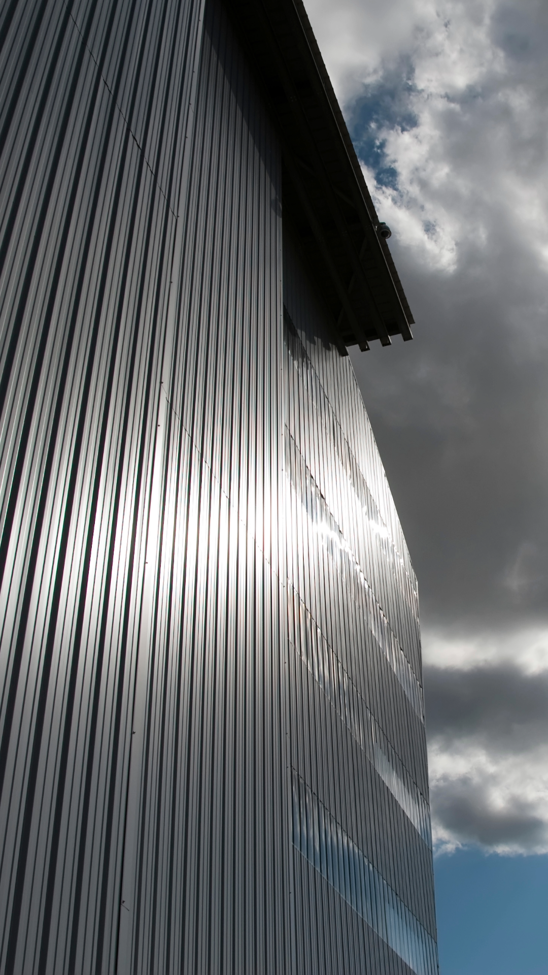 Nettoyage de bardage métallique par drone - Surface industrielle brillante après intervention professionnelle ATN 67 Services sous un ciel nuageux