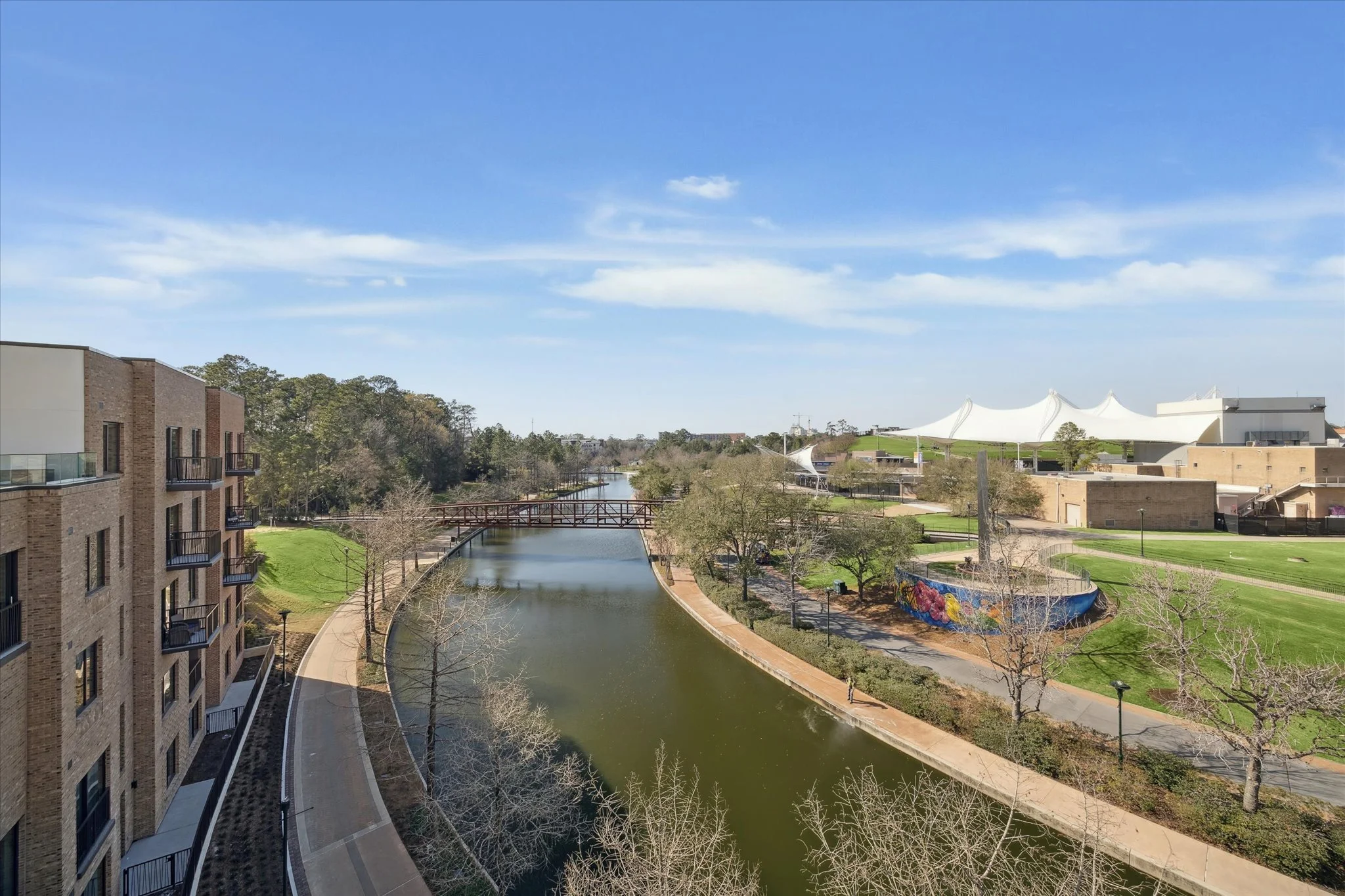 The Woodlands Waterway in The Woodlands, Texas, featuring waterfront apartments, walking paths and green spaces.