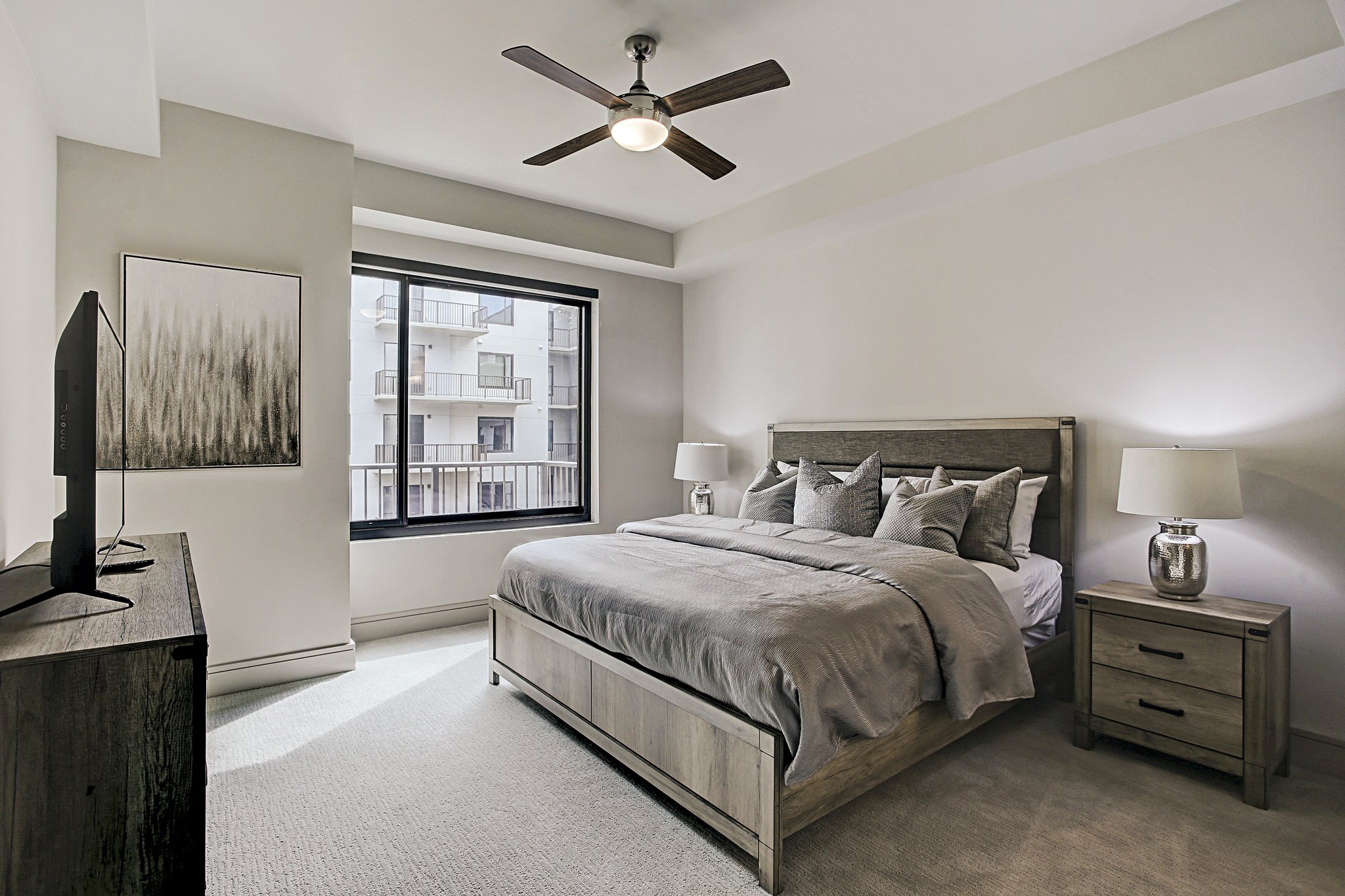 Furnished corporate apartment bedroom in Houston, Texas, featuring a comfortable bed, bedside tables and modern furnishings.