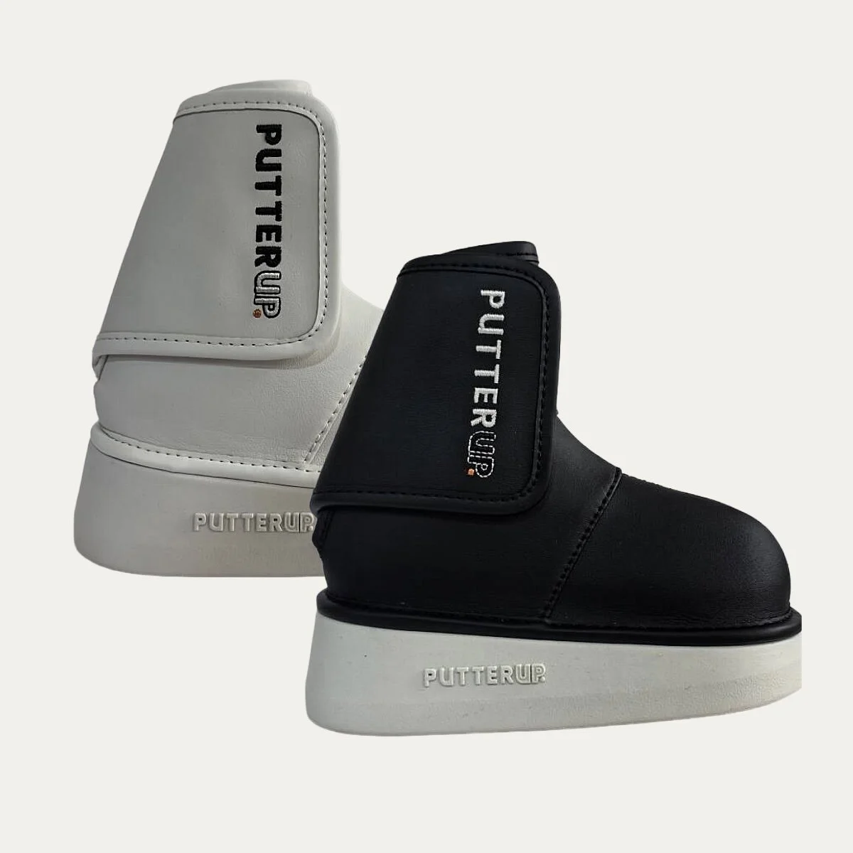 Pair of black and white golf putter covers, branded with 'Putter Up' on the sides and soles.