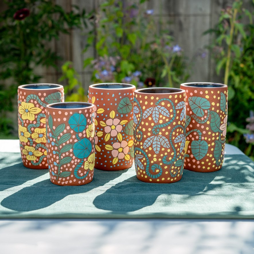 Decorative vases and a jewelry box with floral and dotted patterns, including pink flowers in a white vase.
