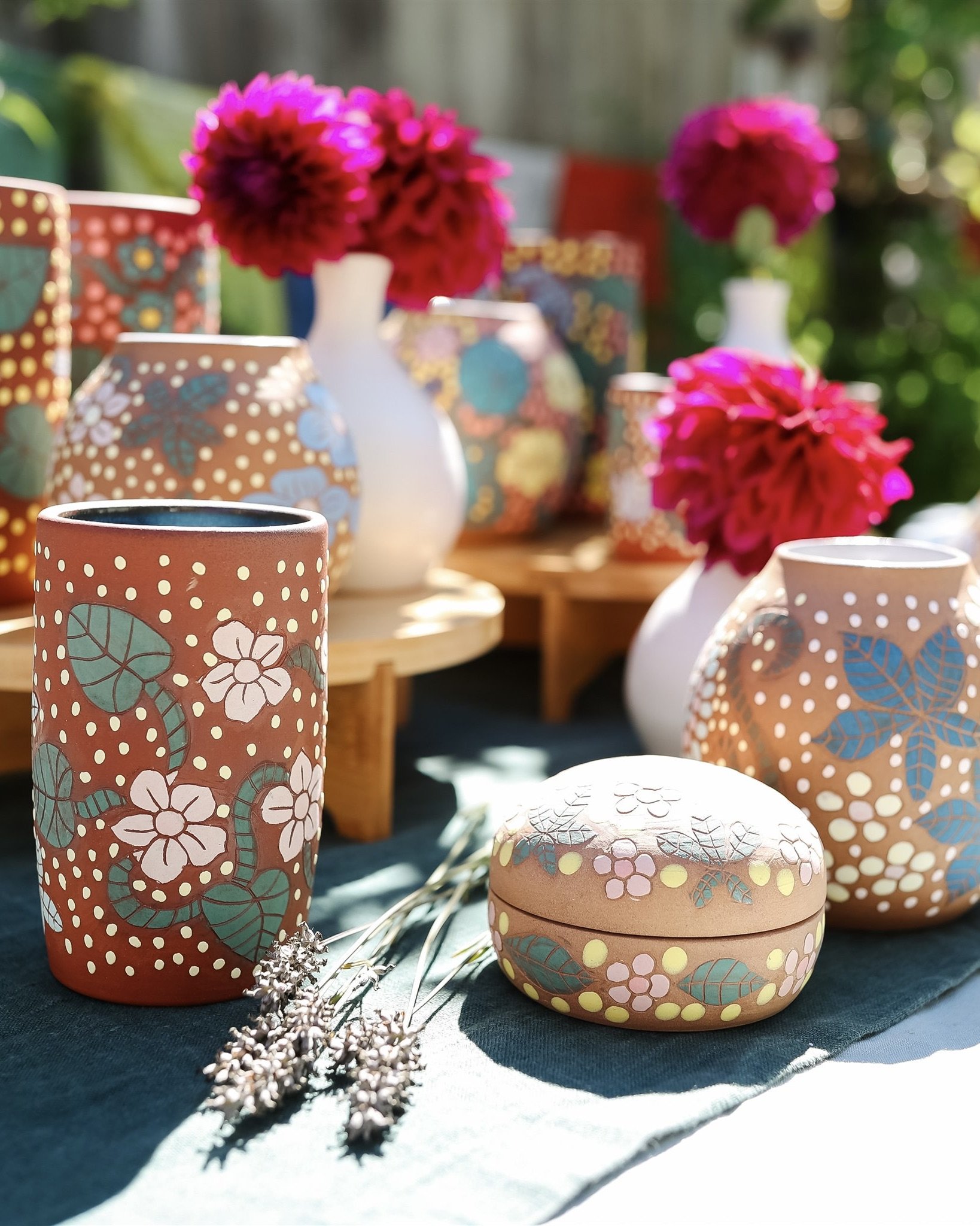 Decorative vases and a jewelry box with floral and dotted patterns, including pink flowers in a white vase.