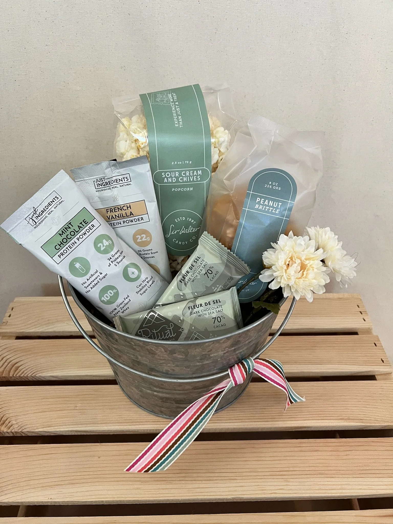 Wasatch Gift snack basket with Ritual Chocolate, Sir Walter peanut brittle, popcorn, and protein powder in a galvanized tin