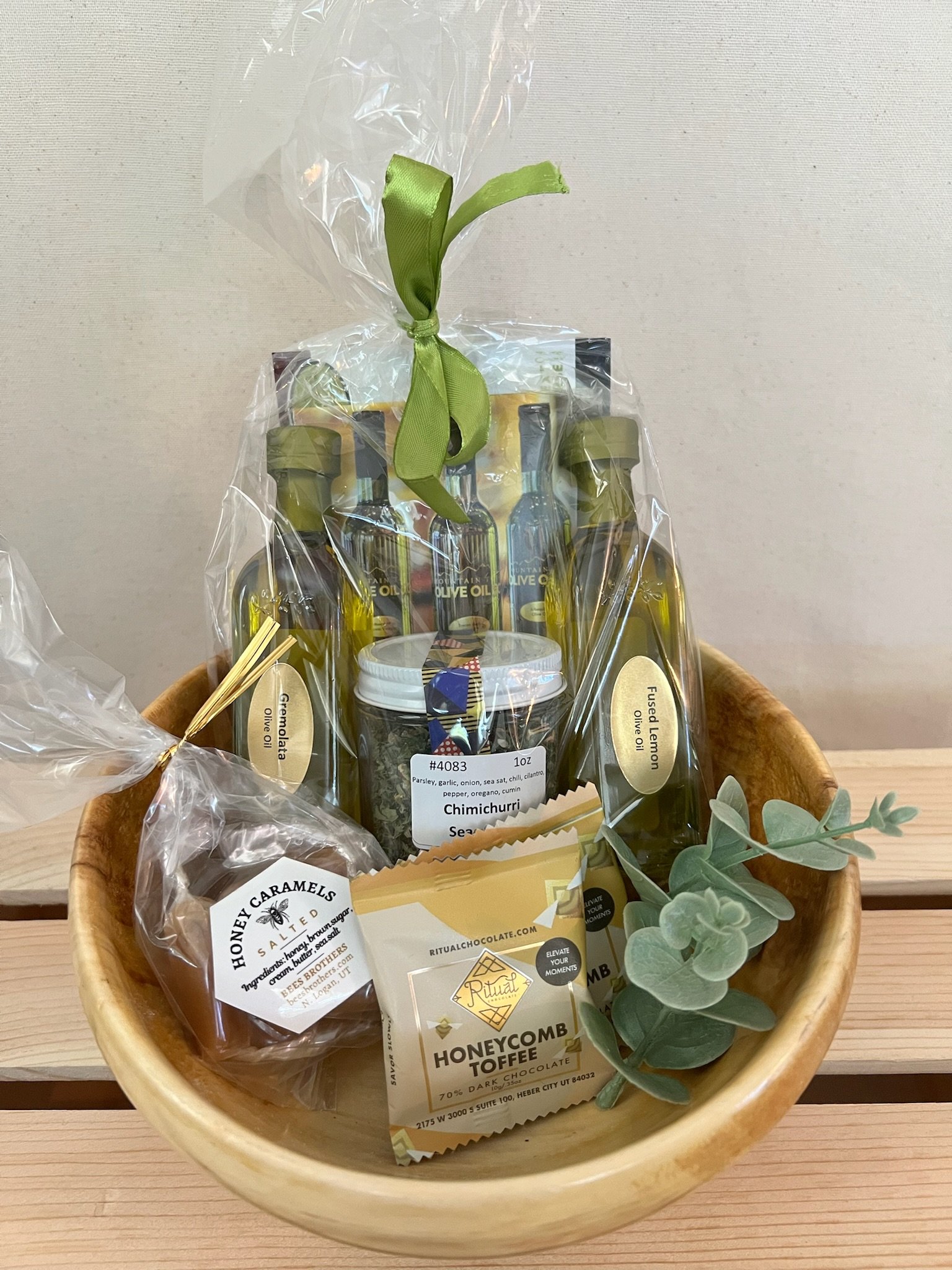 Utah artisan gift basket with olive oil chimichurri kit, Ritual Chocolate, and honey caramels in a handmade wooden bowl