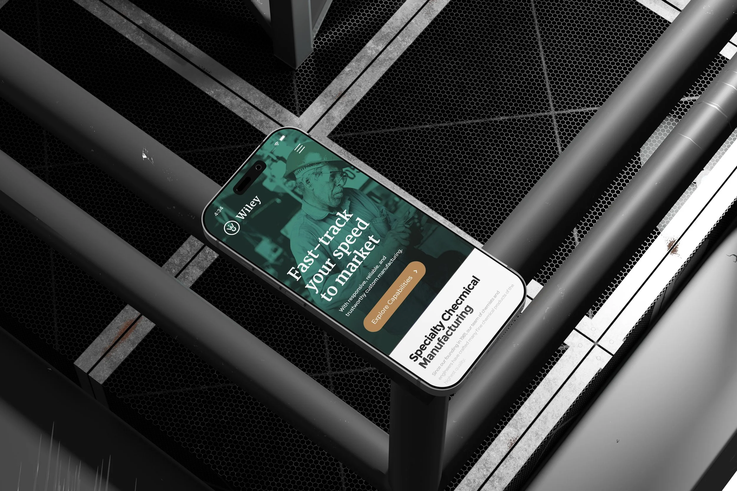 Smartphone displaying a website about chemical manufacturing on a metallic surface.