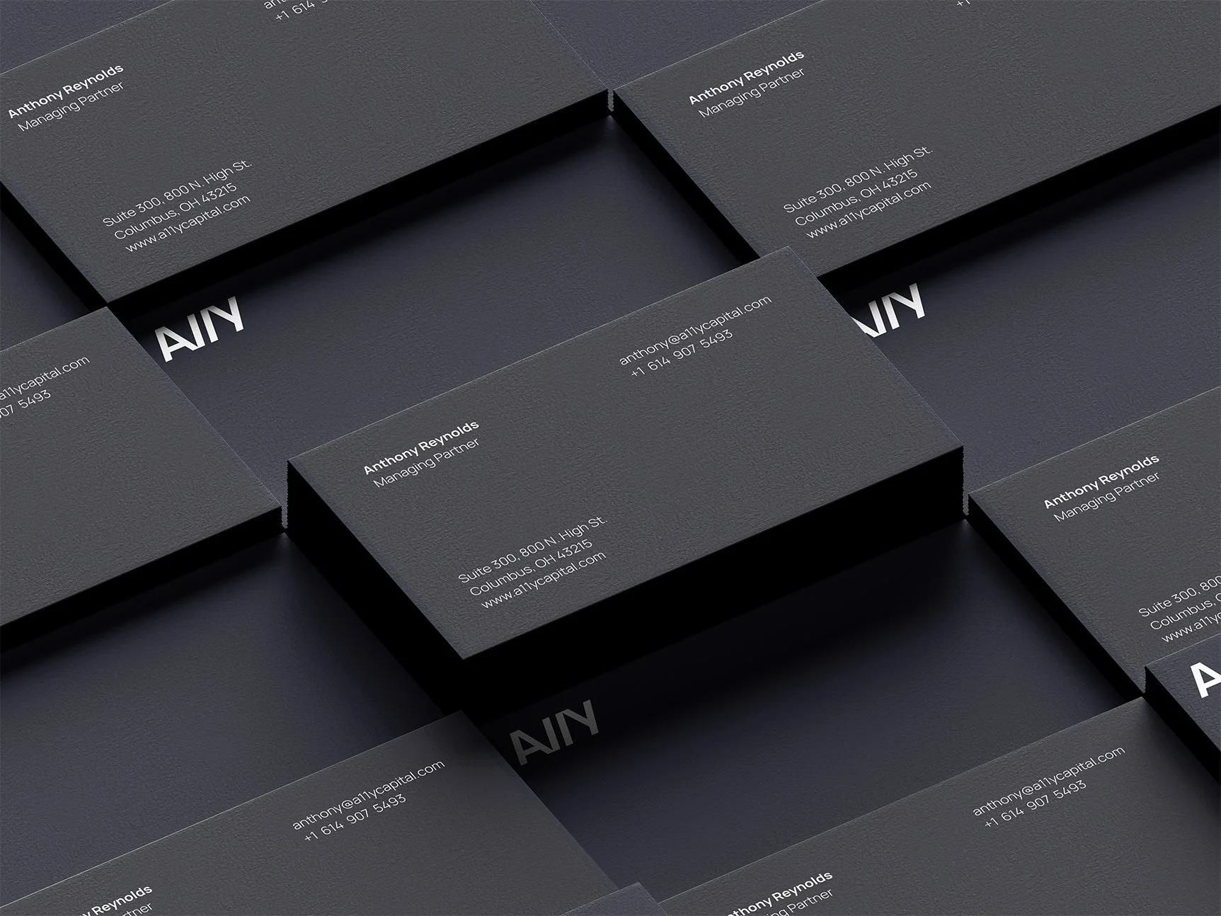 Multiple business cards for Anthony Reynolds, Managing Partner, arranged in overlapping pattern. The cards are dark gray with white text, displaying contact information, address, and website.