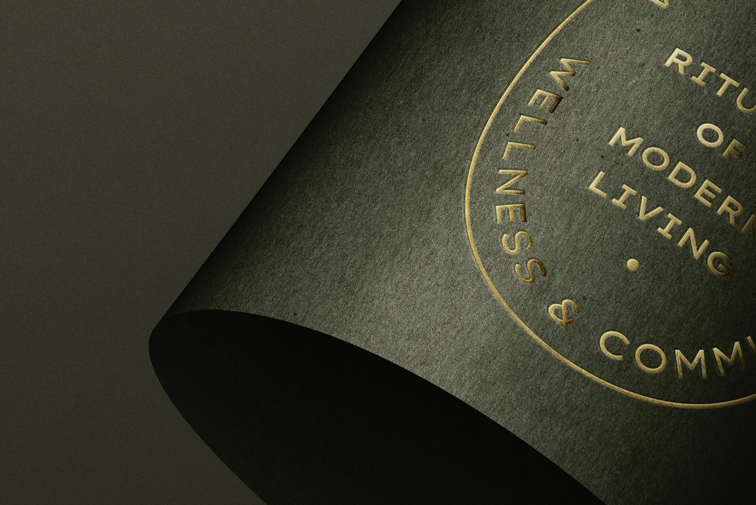 Close-up of a black, textured bottle with gold embossed text and circular design.