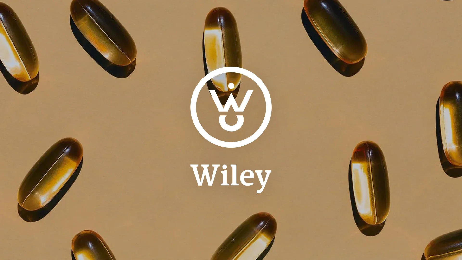 Multiple brown and yellow capsules floating on a beige background with the Wiley logo and name in the center.