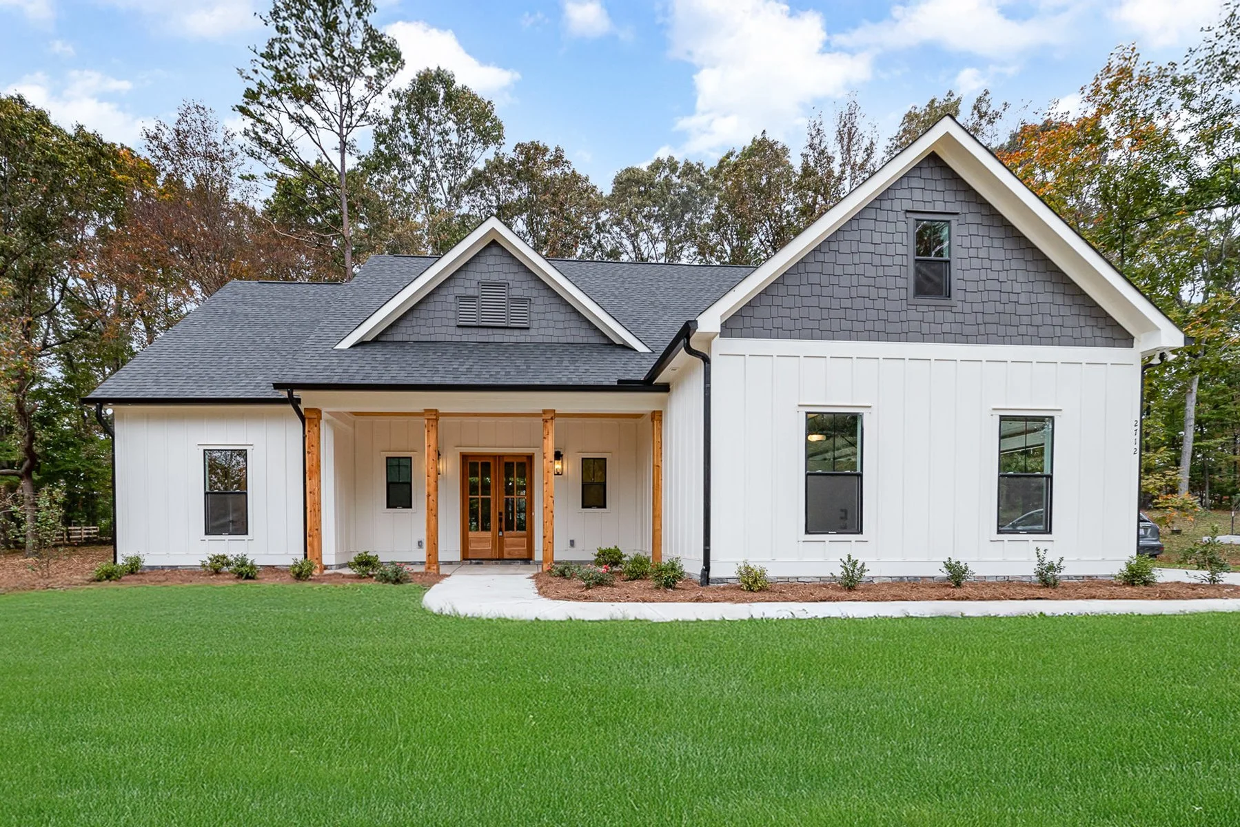 modern farmhouse with white exterior and natural wood accents