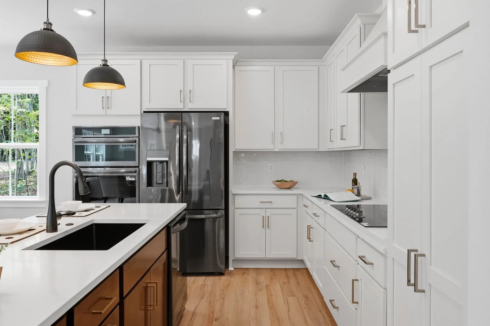 Kitchen with large island and white cabinetry with black accents