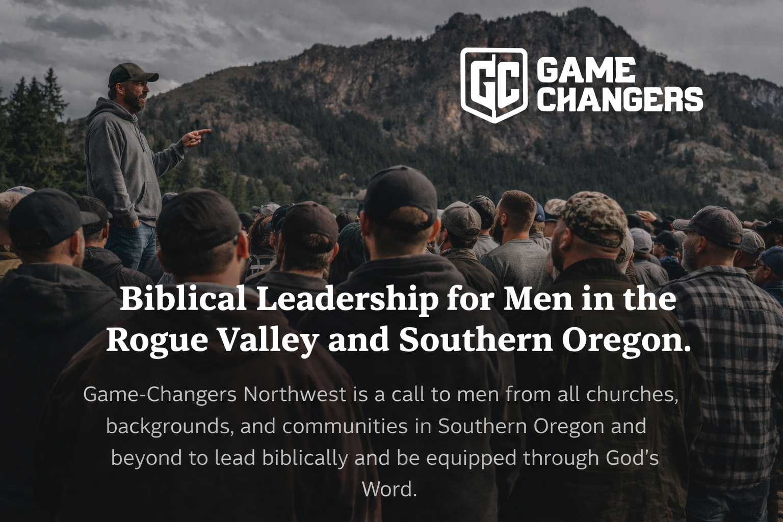 A group of men gathered outdoors in Southern Oregon listening to a speaker as part of a biblical leadership and discipleship gathering.