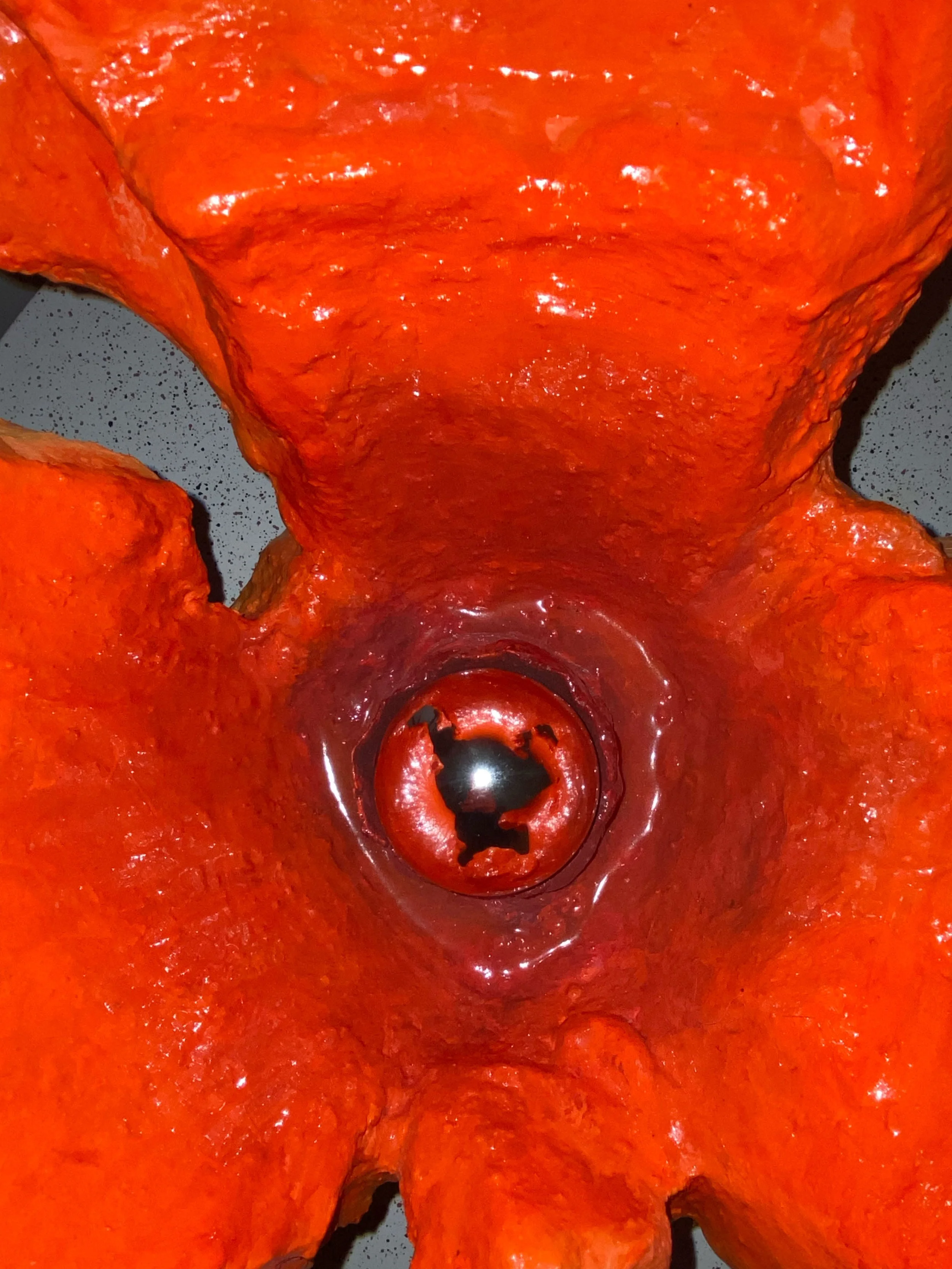 Close-up of an orange bell pepper with its top cut off, exposing the hollow interior and seeds.
