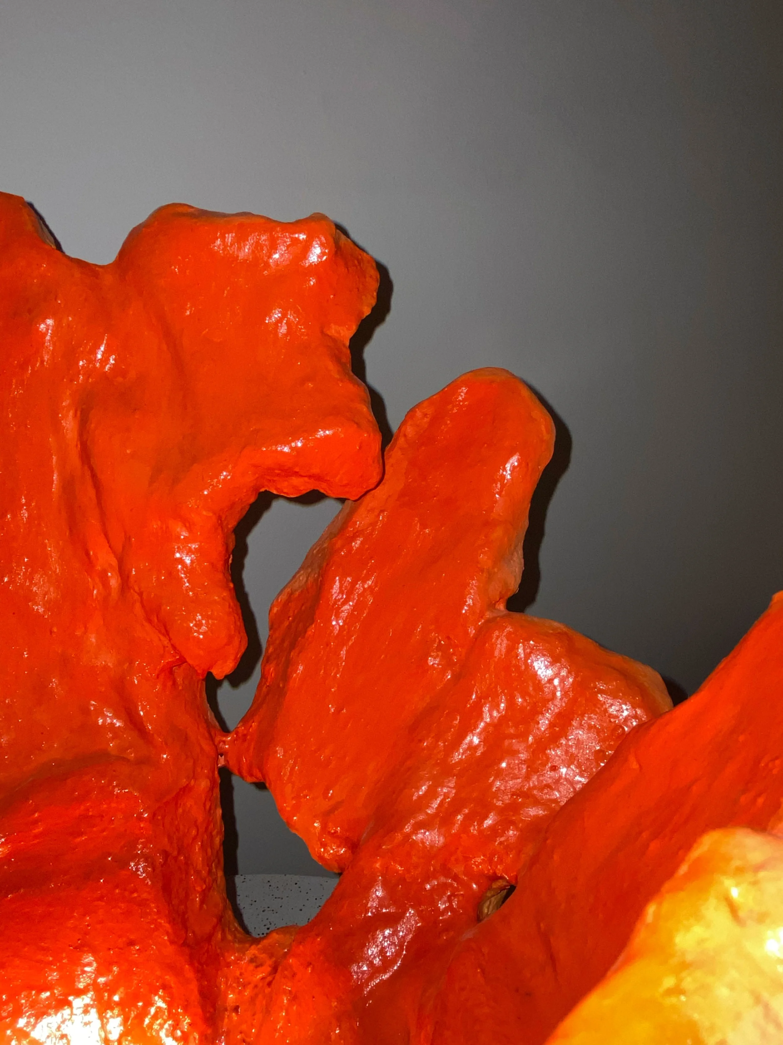 Close-up of bright orange, textured soap carved into abstract shapes.