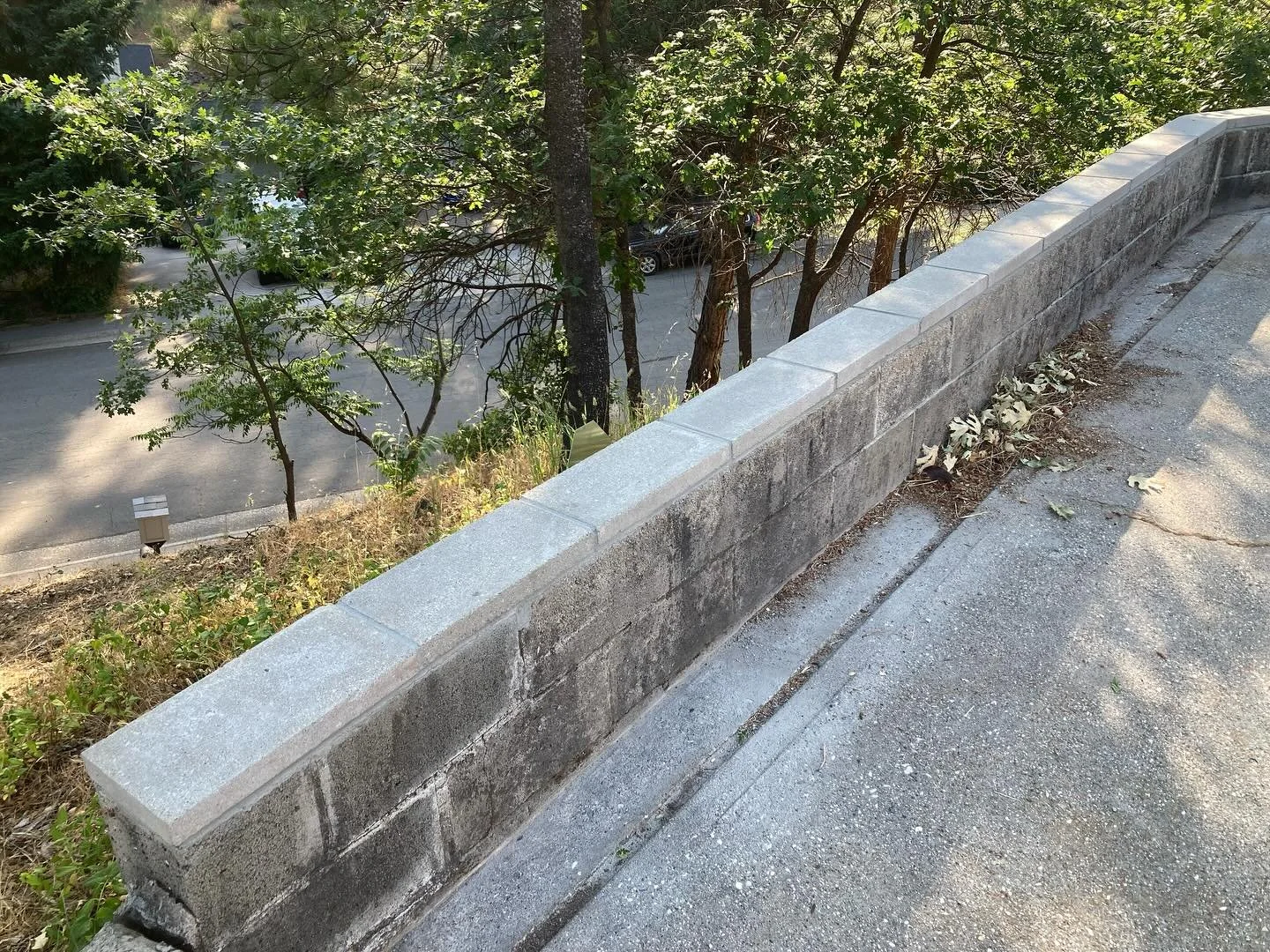 Capstone replacement on an old retaining wall. First removed the old concrete cap with a roto-hammer and chisels. Then mixed mortar and placed new cap. Waited a week for the mortar to set up and then filled all the joints. Much better than the old cr
