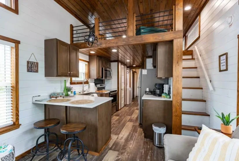 Kitchen and staircase in a cozy, rustic-style home with wood accents and white walls