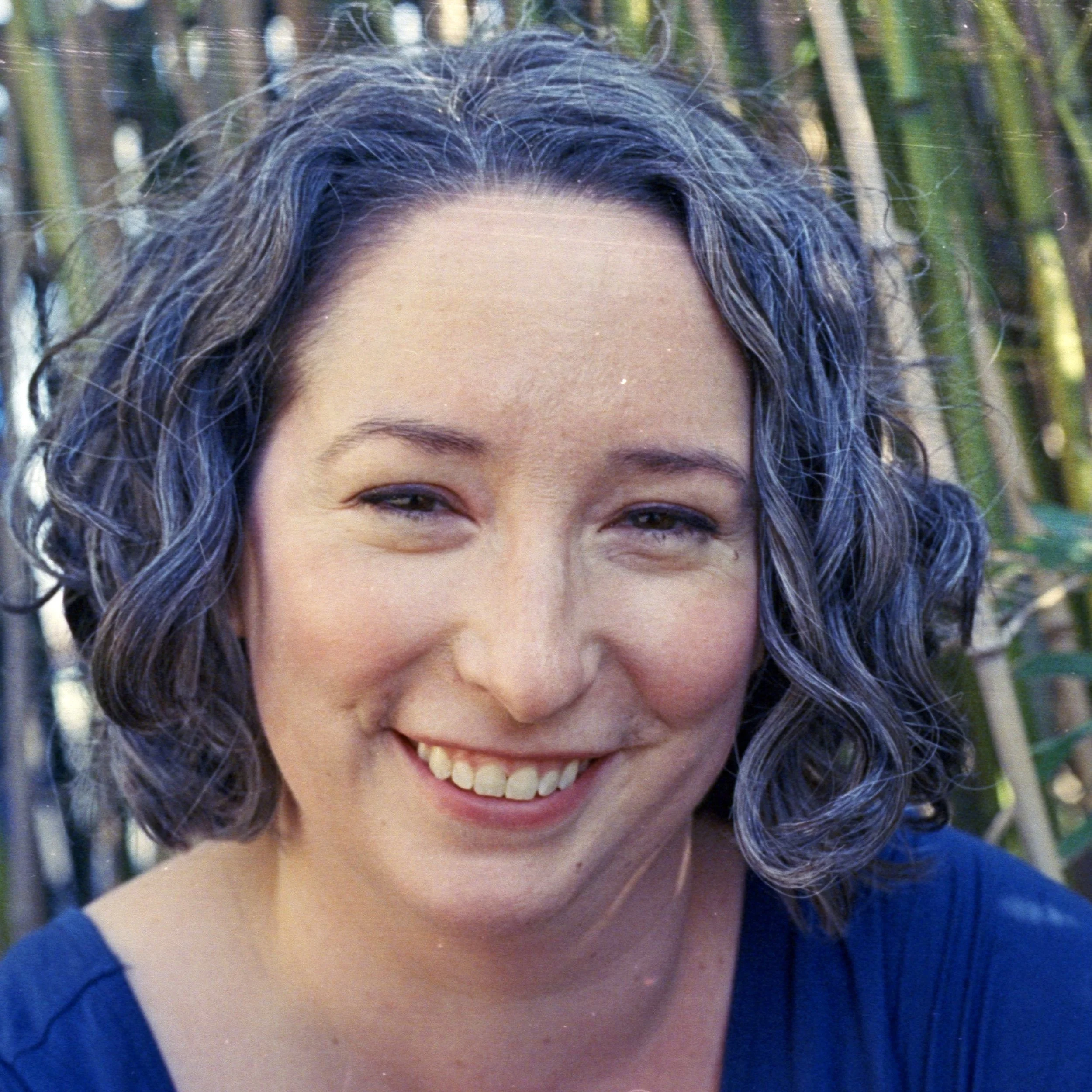 Picture of Dr. Ashleigh (a White cishet woman) in front of bamboo