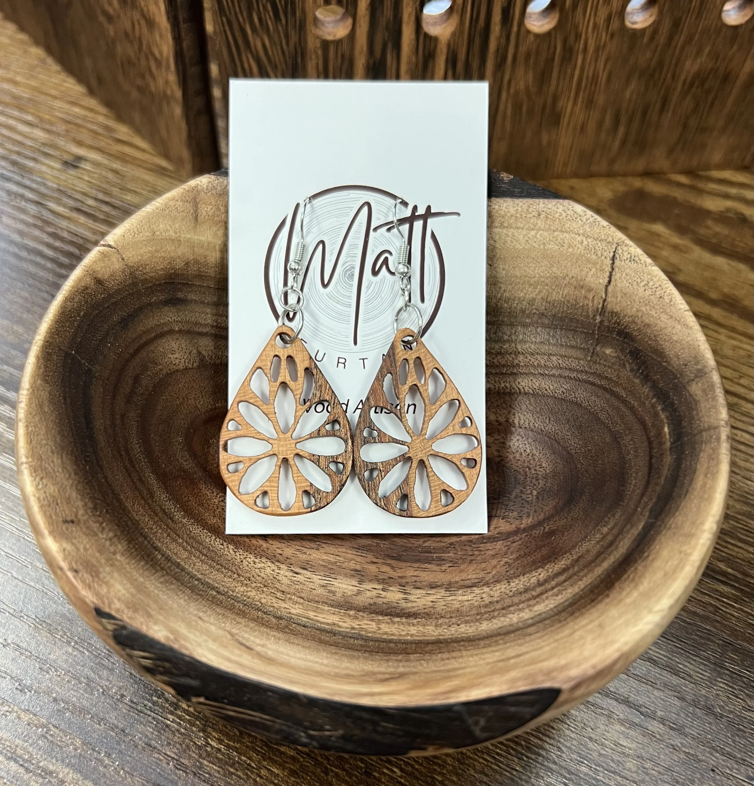 carved wooden earrings inside decorative wooden bowl by artist Matt Furtaw