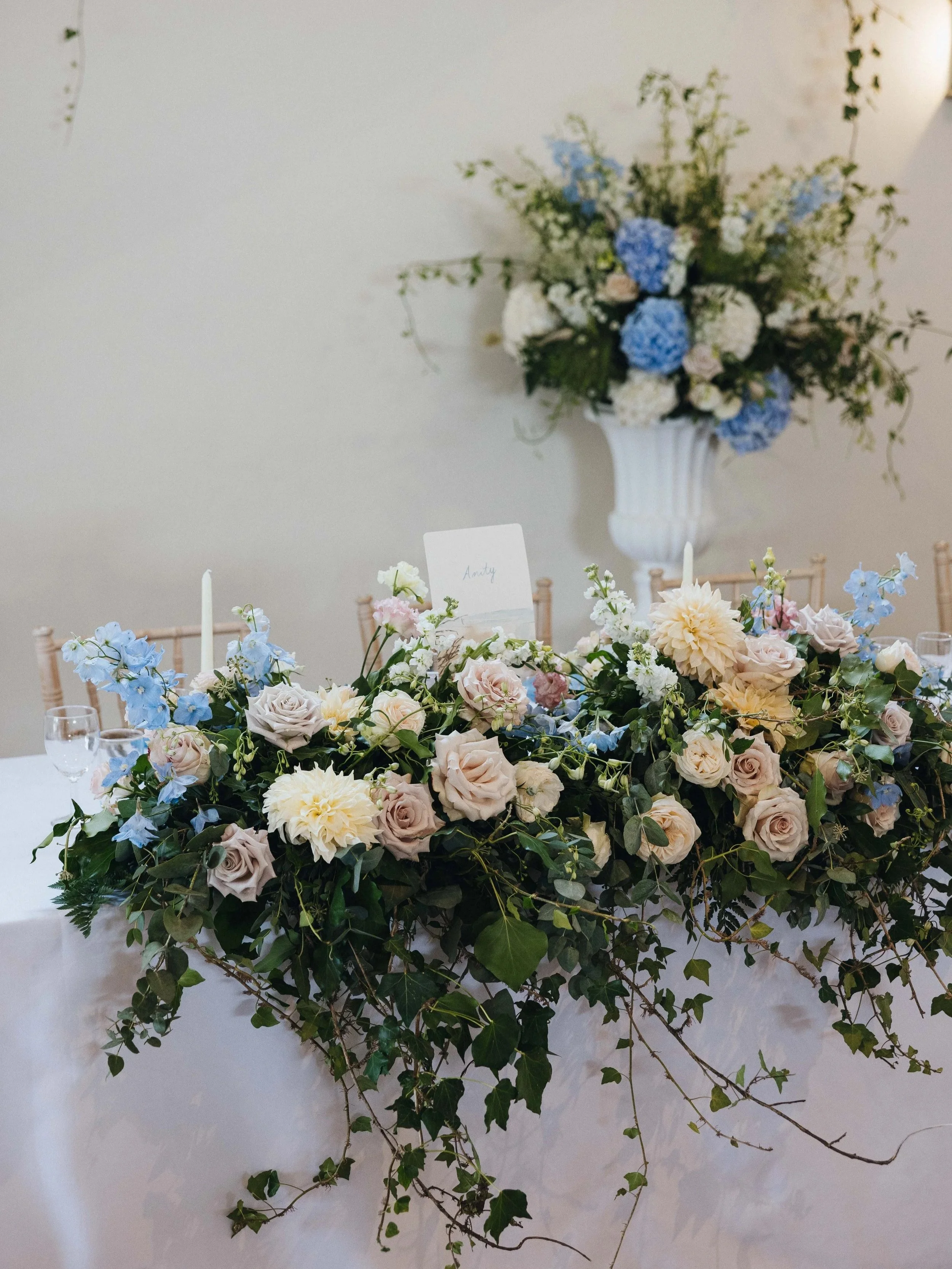 A bespoke illustrated table name featuring a hand drawn beach for each table and hand written names at Launcells Barton