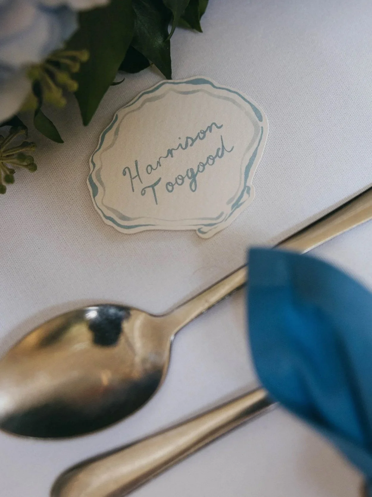 Bespoke cut illustrated shell  place card for a wedding in Cornwall featuring hand written names of each guest
