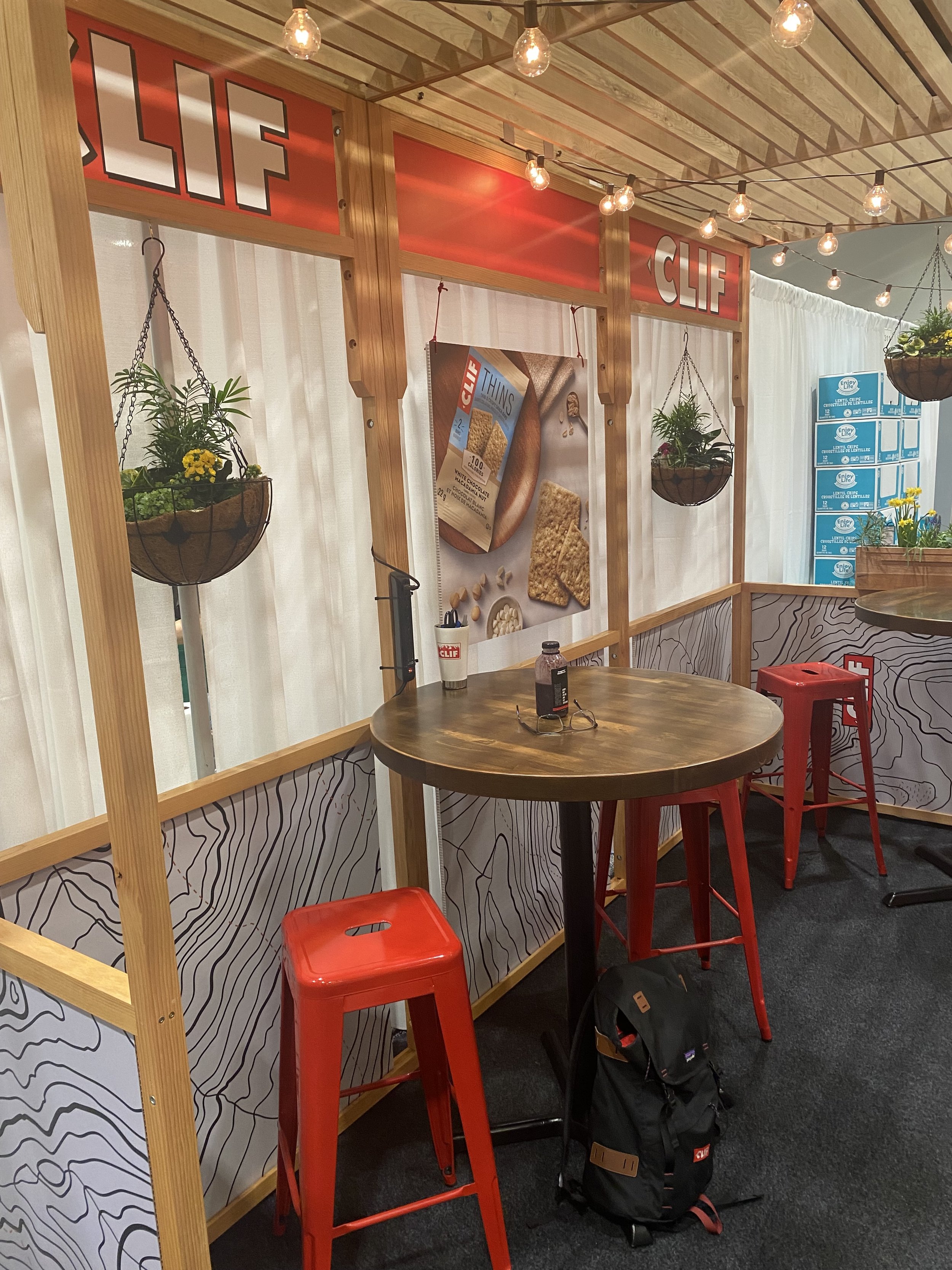 The inside of the Cafe with soft lighting, comfortable bar top seating and hanging plants.
