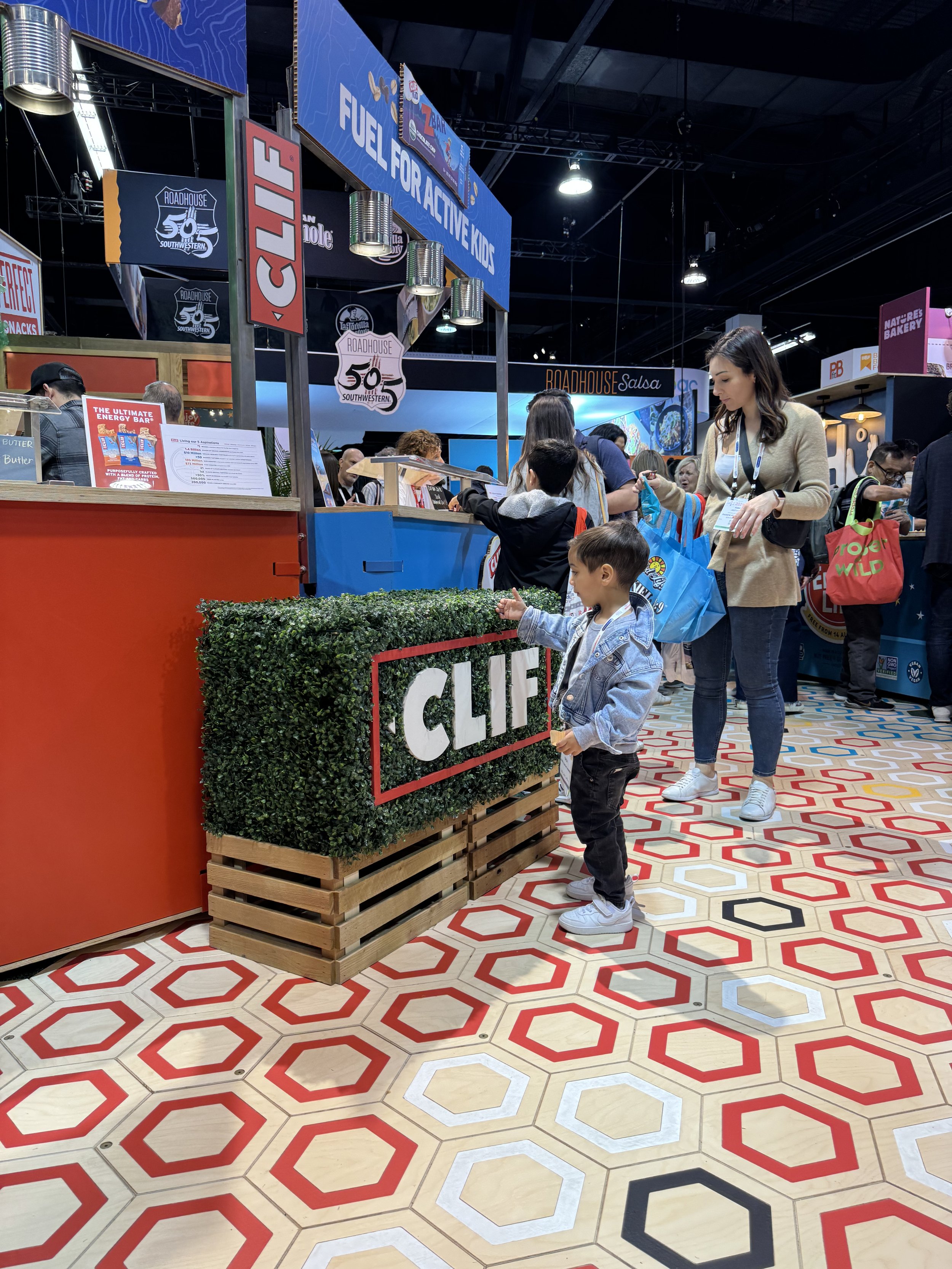 Clif sampling counters, Pathway through the booth with brand colors represented in the hexagons.