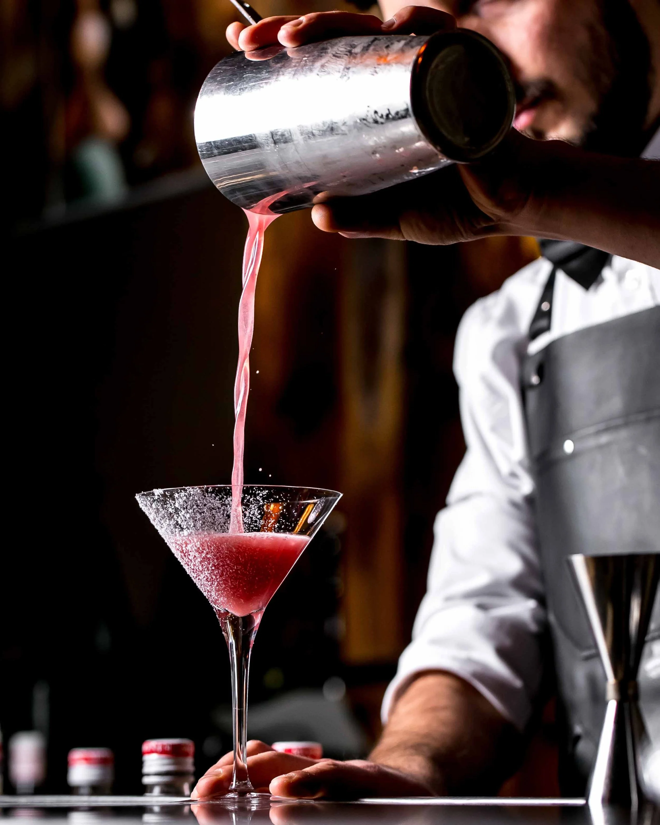 bar-tender-pours-cocktail-from-cocktail-shaker-into-martini-glass.jpg