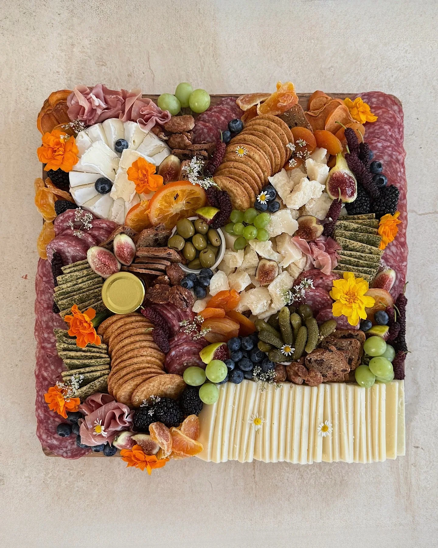 Our small grazing board 💫

Feeds 5&ndash;10 and includes 3 cheeses, 3 meats, crackers, olives, pickles, nuts, dried + fresh fruit, and edible flowers.

The prettiest way to snack, if you ask us. 🧀🍇🫐🫒🌼

 #grazingtable #charcuterieboard #charcute