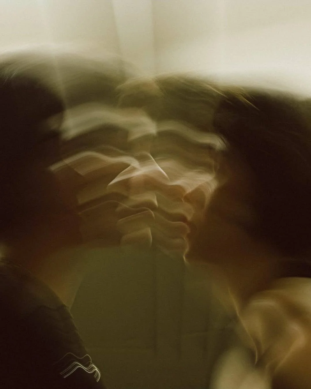 Imagen borrosa con líneas onduladas y colores oscuros y claros, sin elementos claramente identificables.