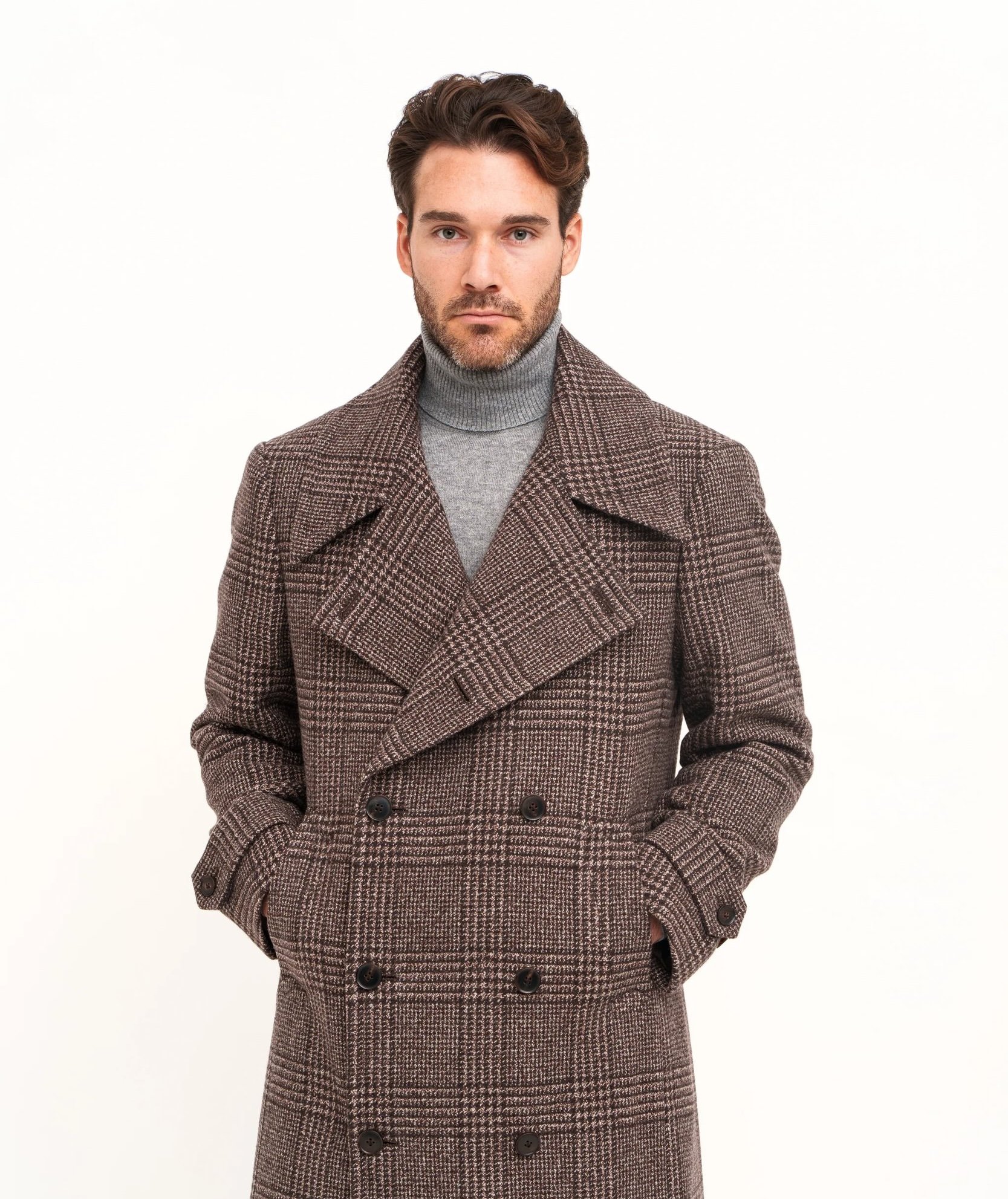 Man wearing a brown plaid double-breasted coat with a gray turtleneck sweater.