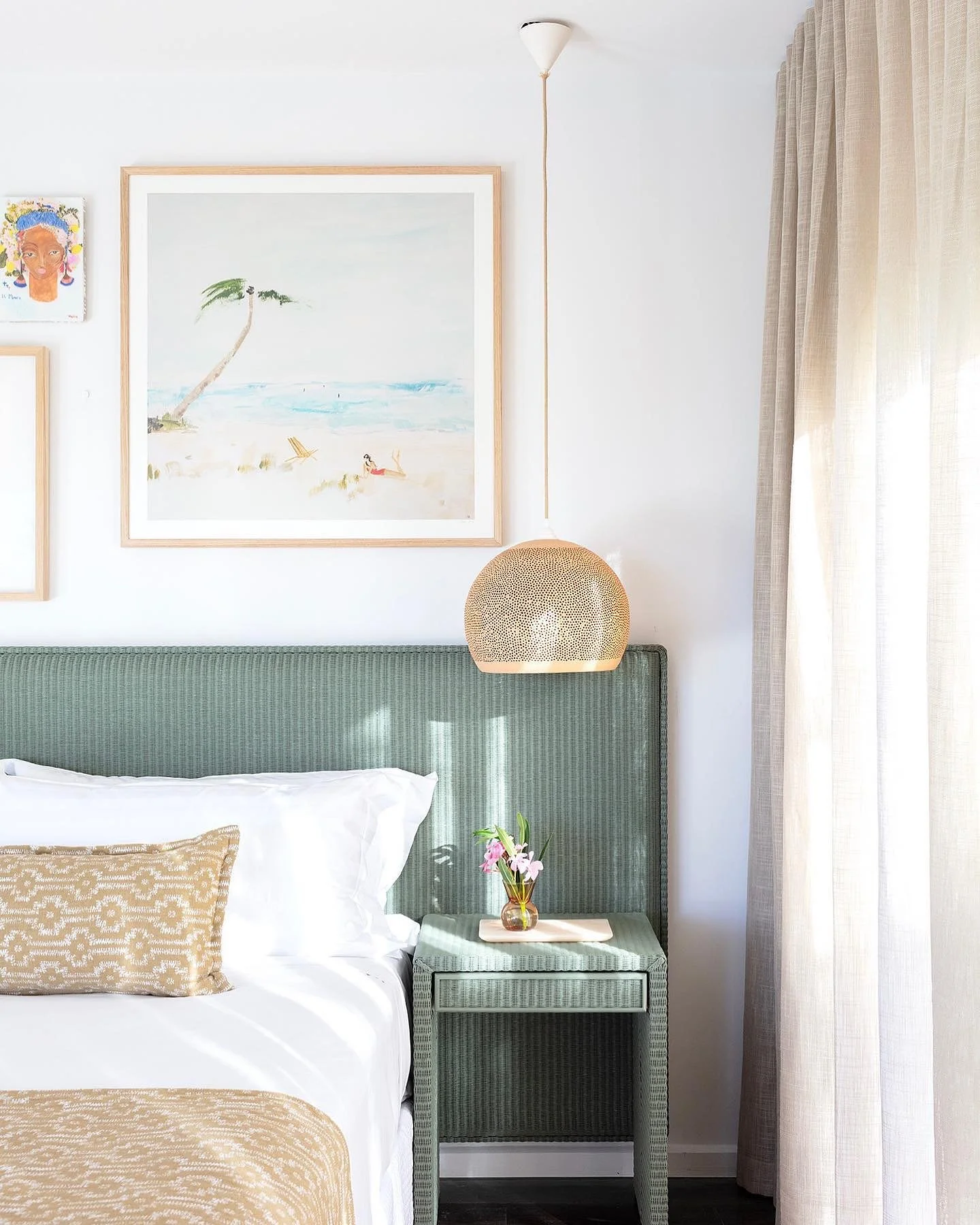 This picture-perfect holiday home bedroom invites you to unwind and embrace tranquility, enveloped in soothing textures and serene colours. The combination of soft fabrics, playful artwork and carefully curated furnishings creates an inviting atmosph