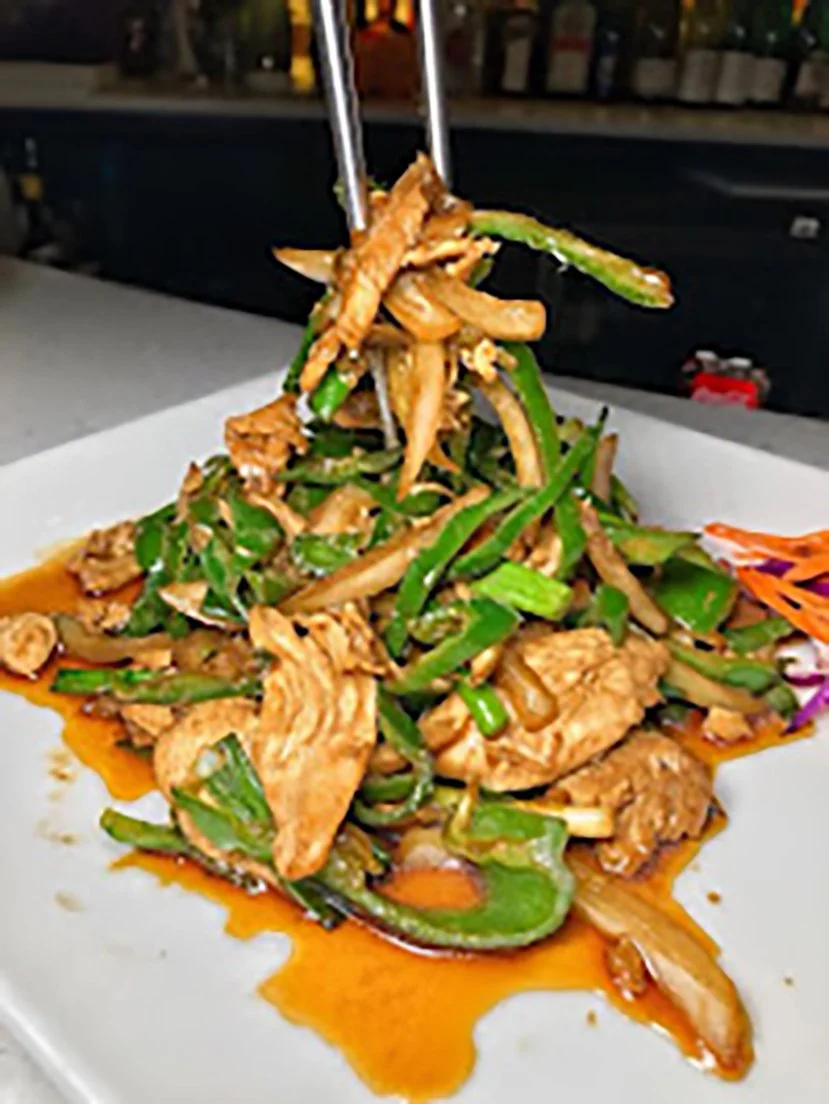 Stir-fried chicken and vegetables on a white plate