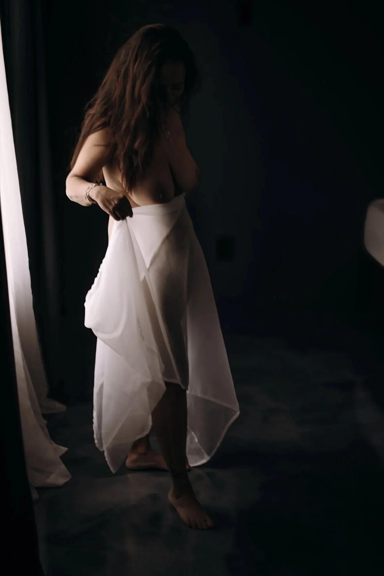 A sheer robe and soft movement create a dreamy, fine art boudoir moment.
