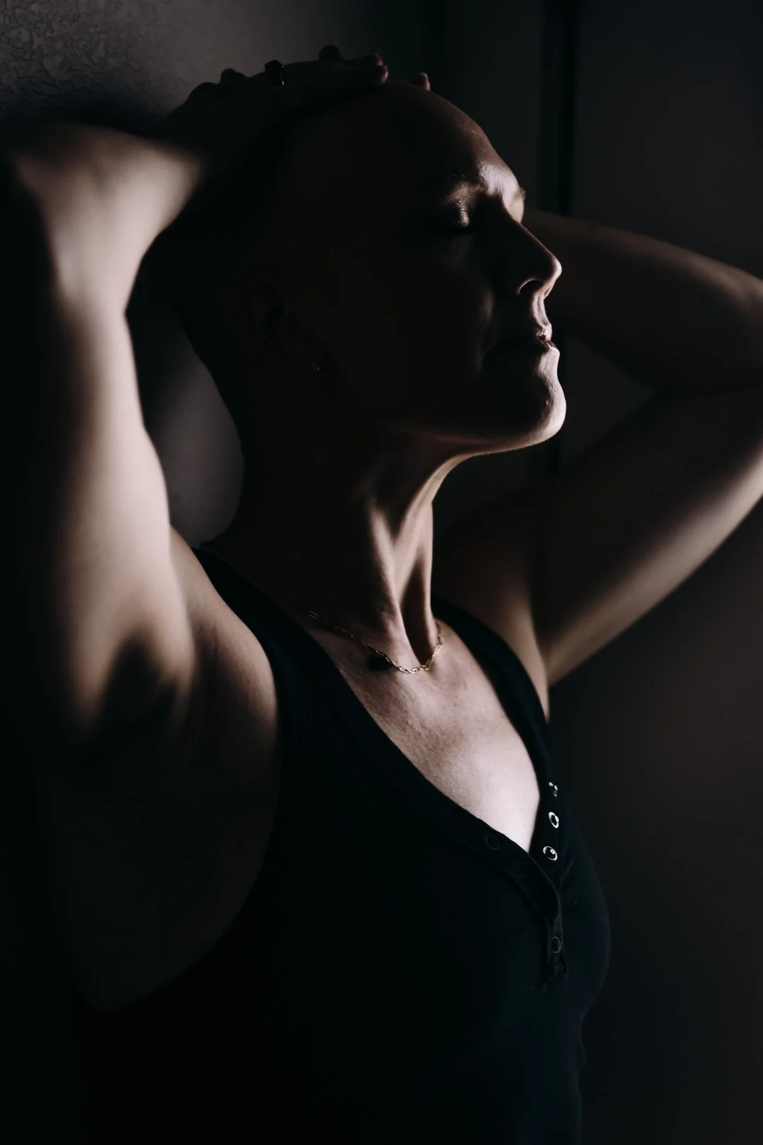 Side profile portrait of a strong woman, boudoir session honoring resilience and feminine power