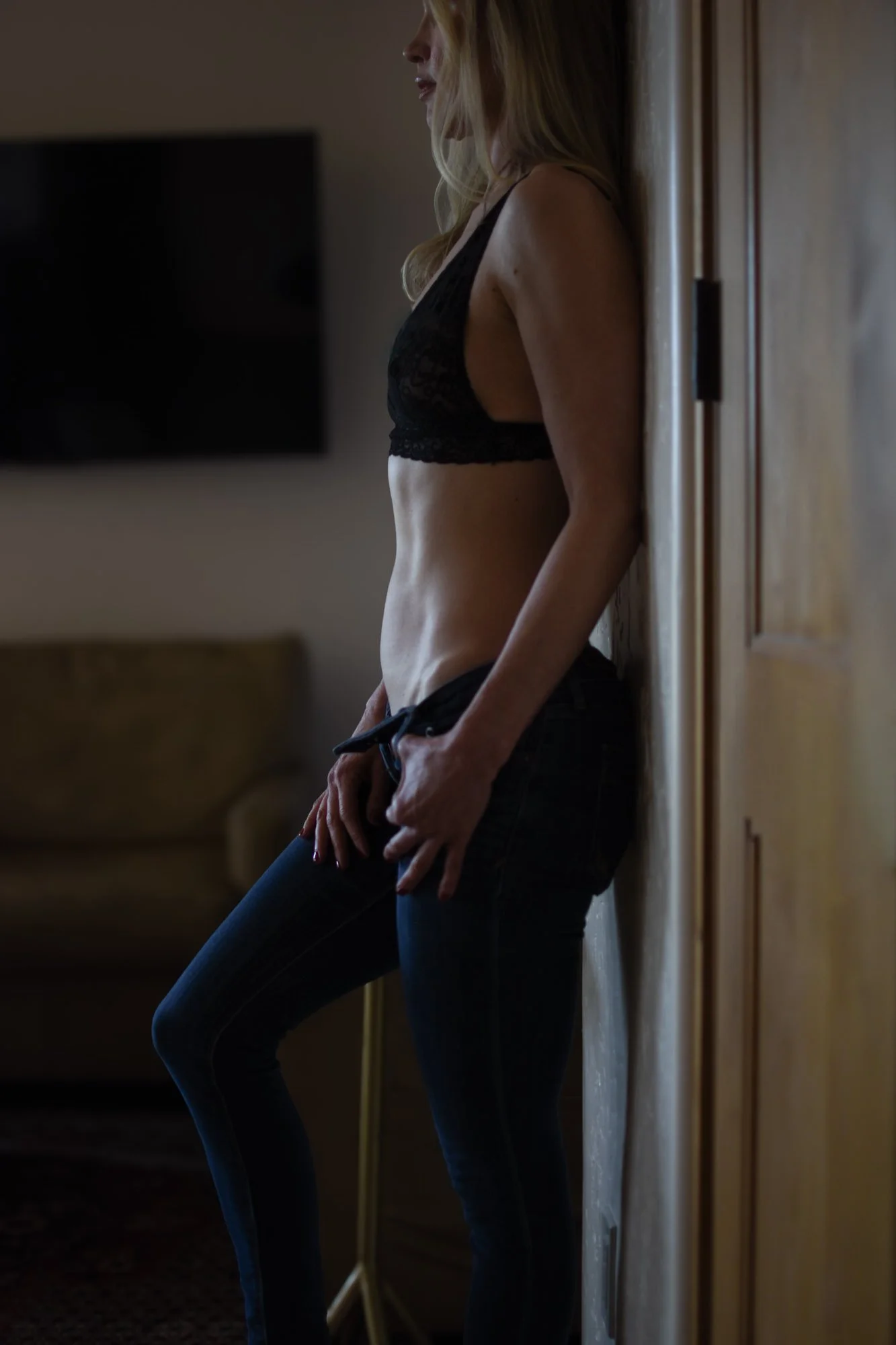 Luxury fine art portrait by the best photographer in Tucson, Arizona, featuring a woman in black lingerie standing in soft natural light.