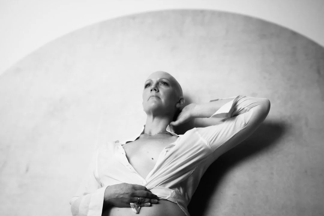 Empowering black and white cancer survivor portrait of a woman looking upward during a fine art boudoir photography session by Tucson photographer Rebekah Ayantola.