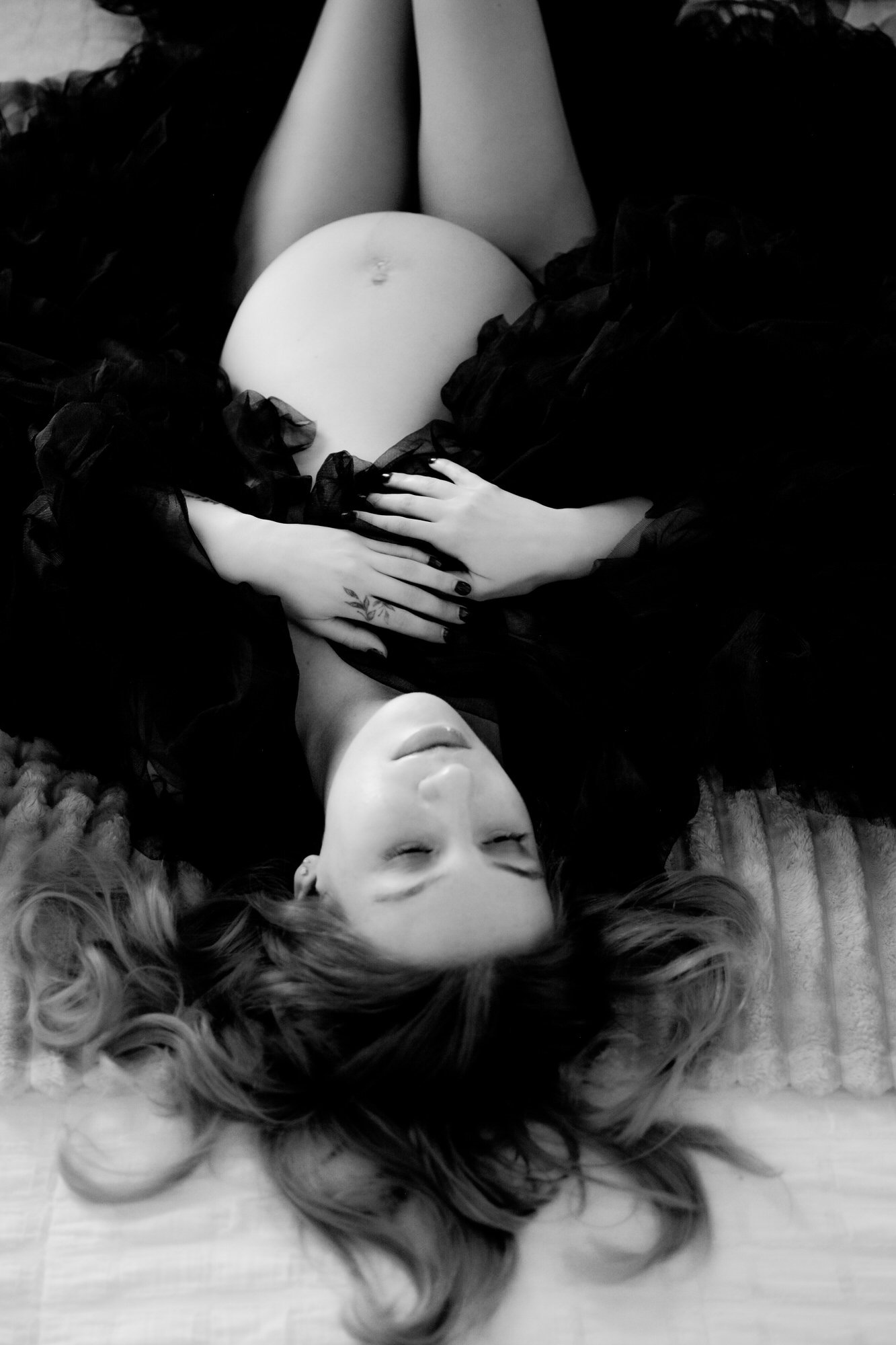 An expecting mother photographed during a fine art maternity photo shoot in Tucson, Arizona. This timeless black and white maternity portrait celebrates motherhood, pregnancy, and feminine beauty through elegant styling and artistic composition by Tu