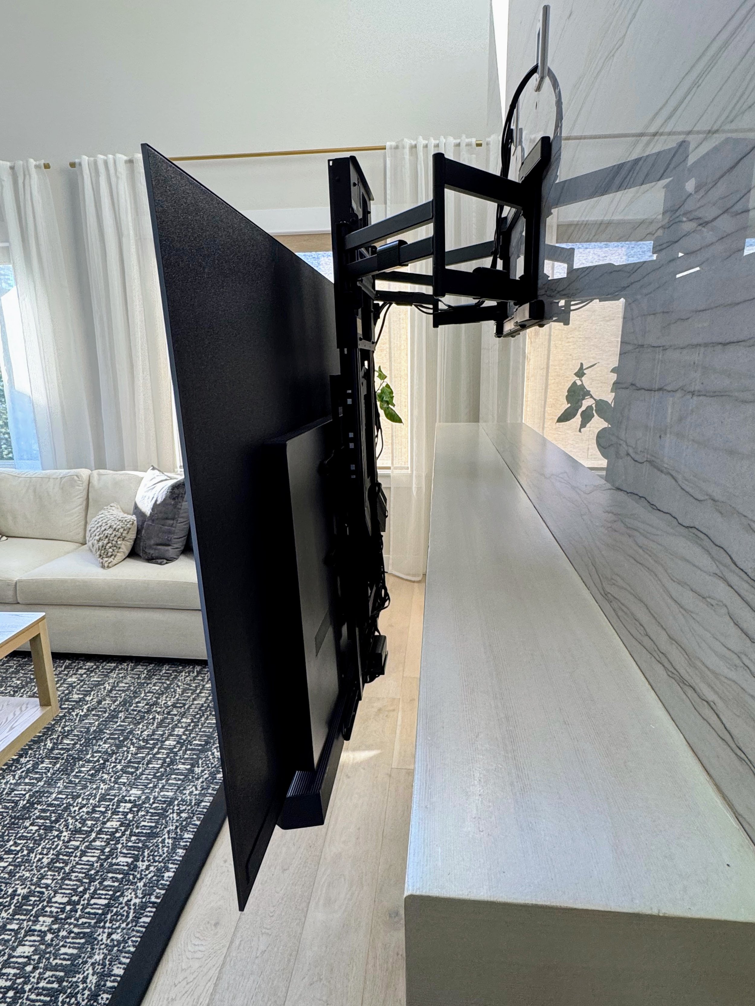 Side profile of a Tv mounted on quartz tiled fireplace with MantelMount MM815 Pro with a LG C5 77" TV , Sonos Arc Ultra. Camas Washington Toll Brothers