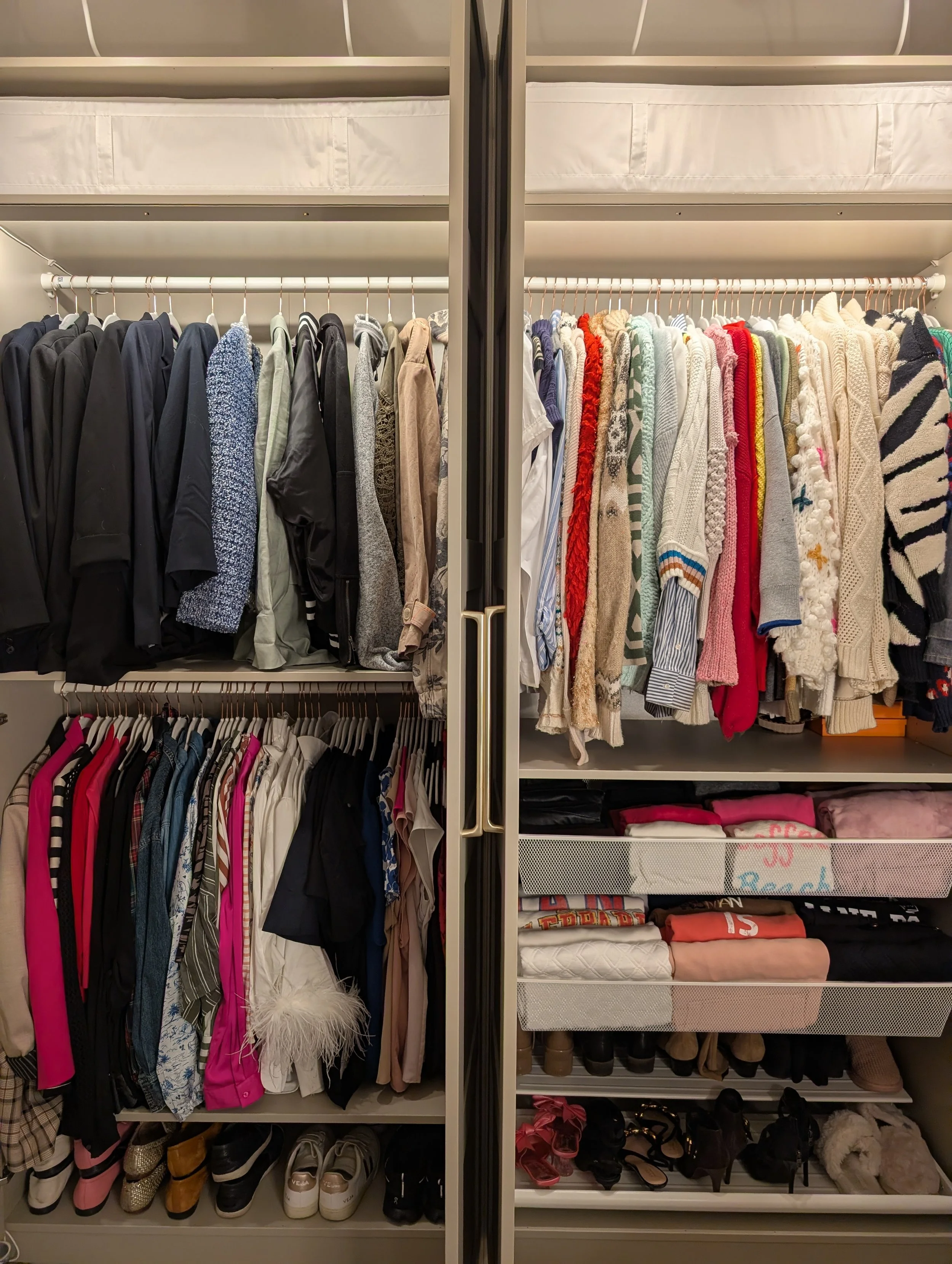 Primary closet with neatly organized clothing, shoes, and accessories on shelves and hanging rods.